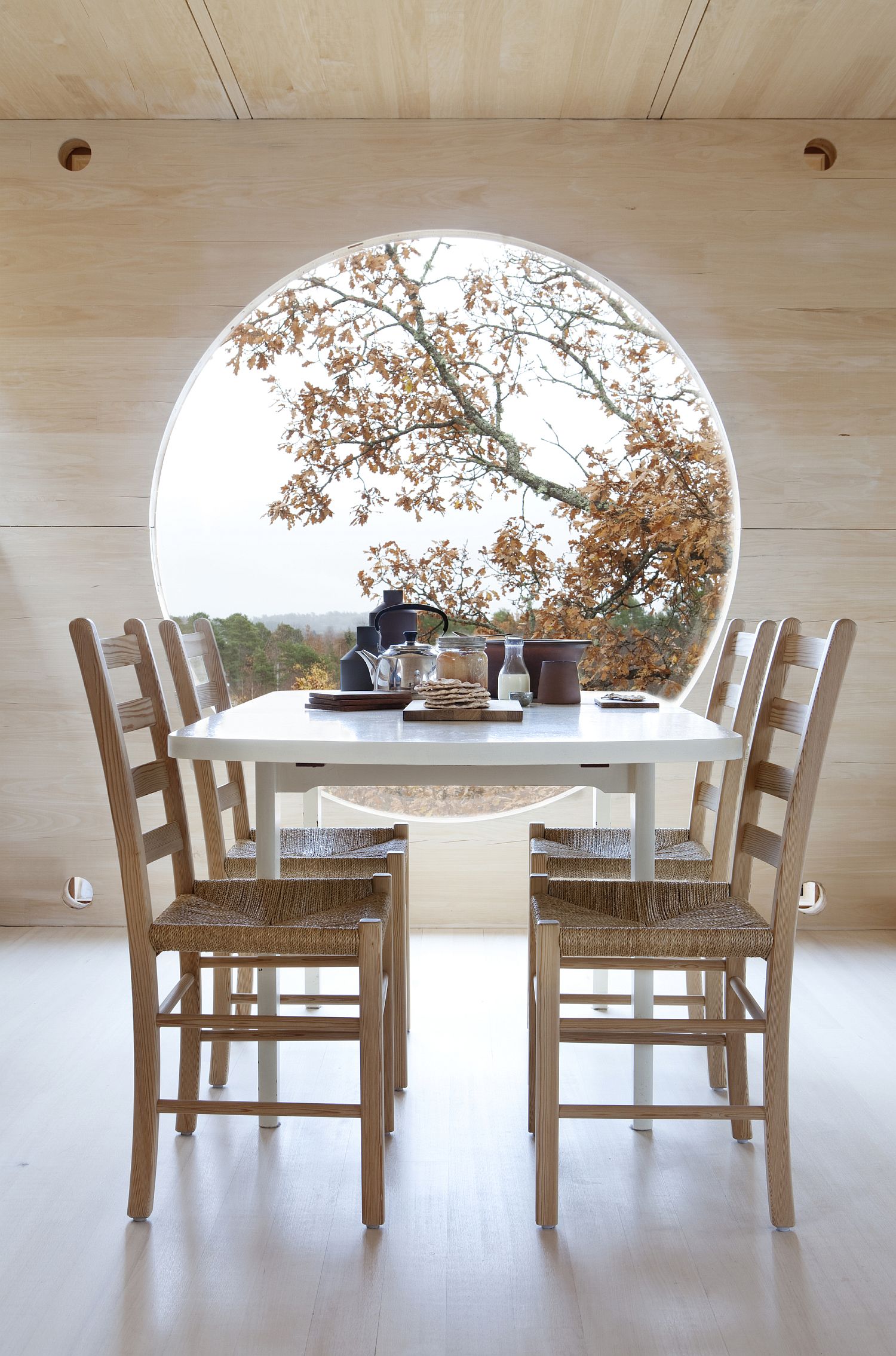 Picture-perfect dining room with round window overlong the distant fjords
