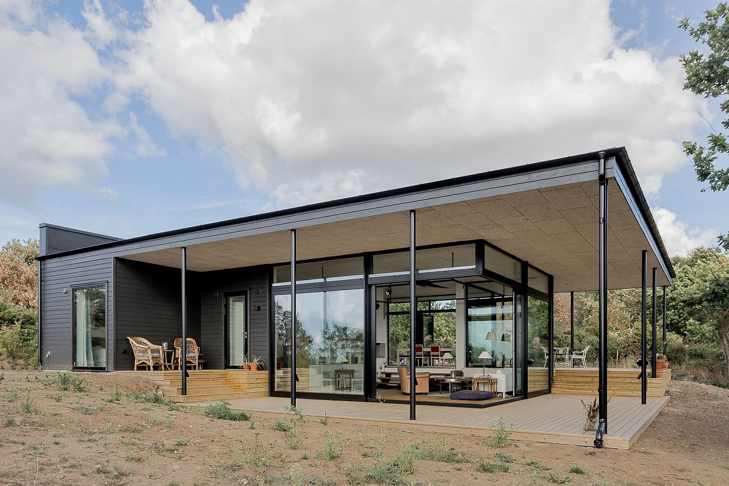 Slim metal beams extend the roof outside and create the perfect shaded terrace