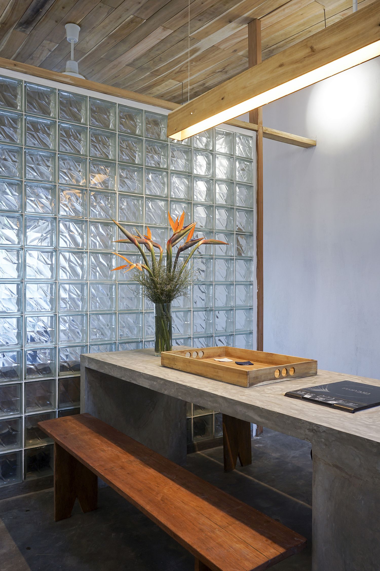 Concrete dining table with wooden bench keeps things simple and minimal