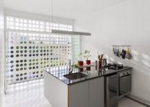 Concrete-wall-with-circular-cutouts-brings-light-into-the-kitchen-217x155