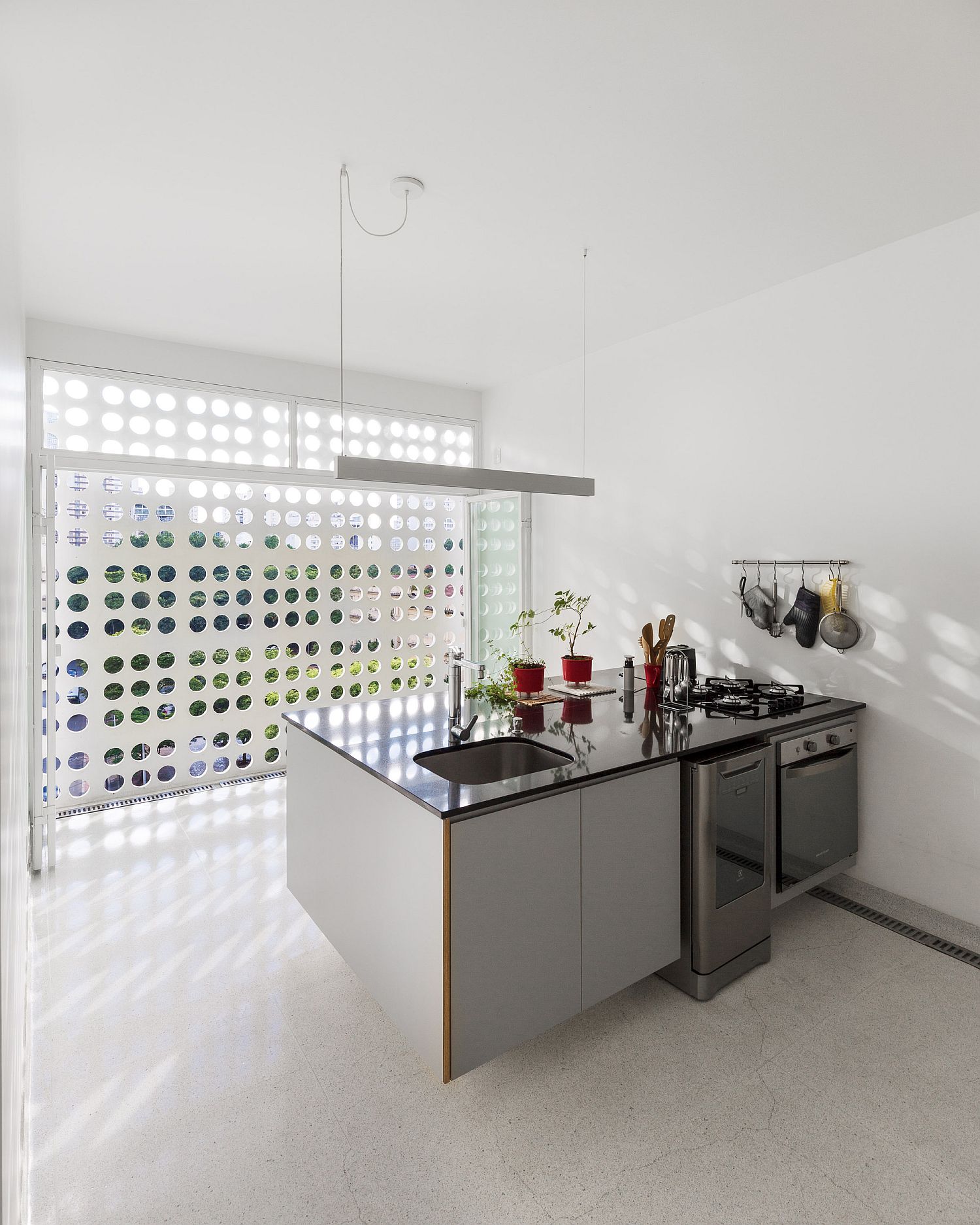 Concrete wall with circular cutouts brings light into the kitchen