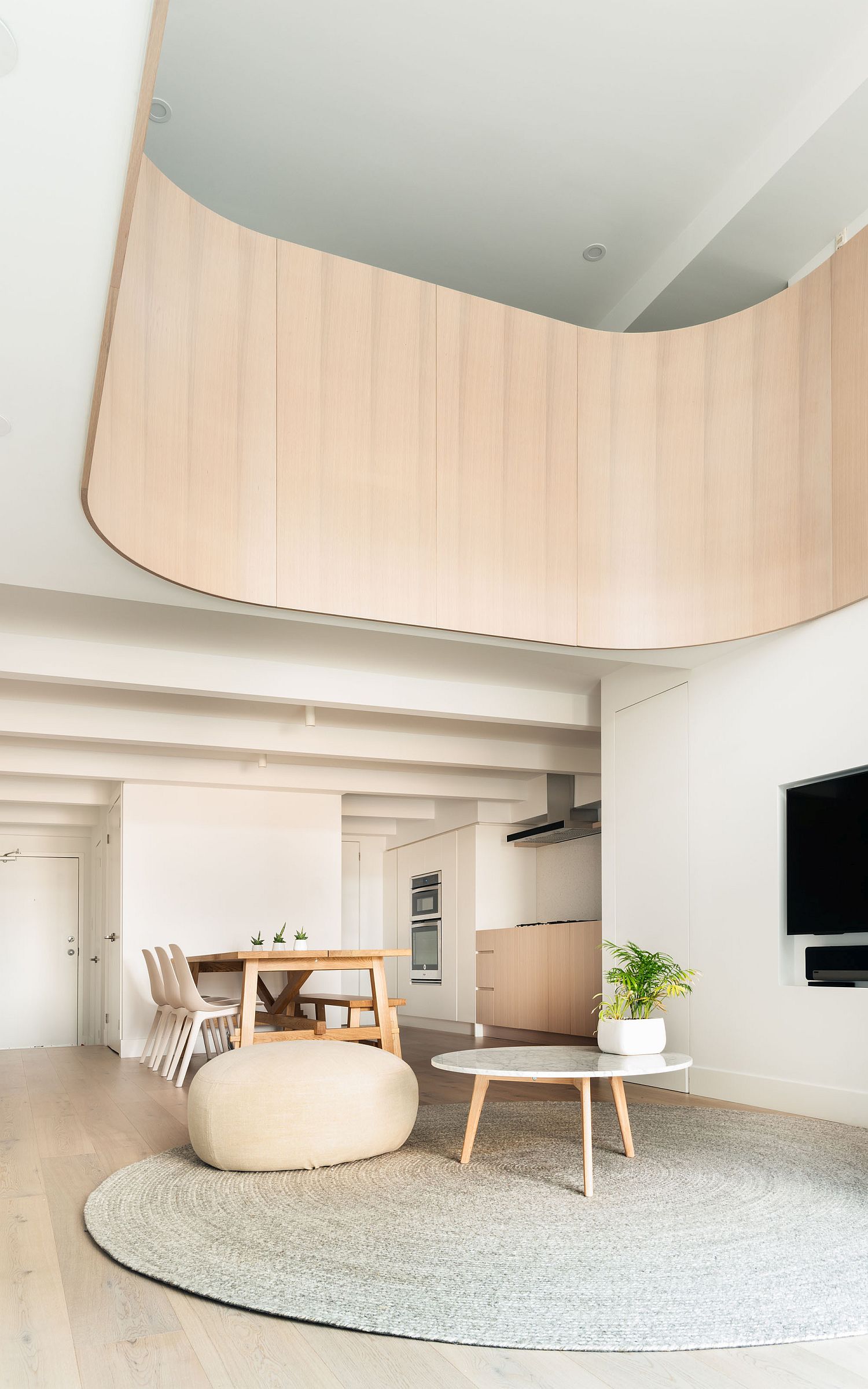 Curved wooden element lends softness to the minimal modern interior