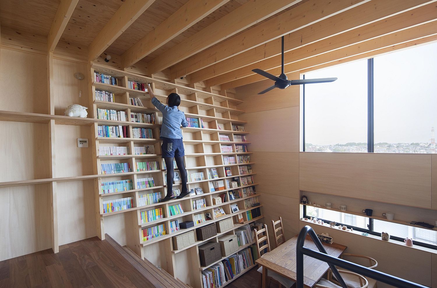 Double-height-living-room-with-bookshelf-wall-is-simply-stunning