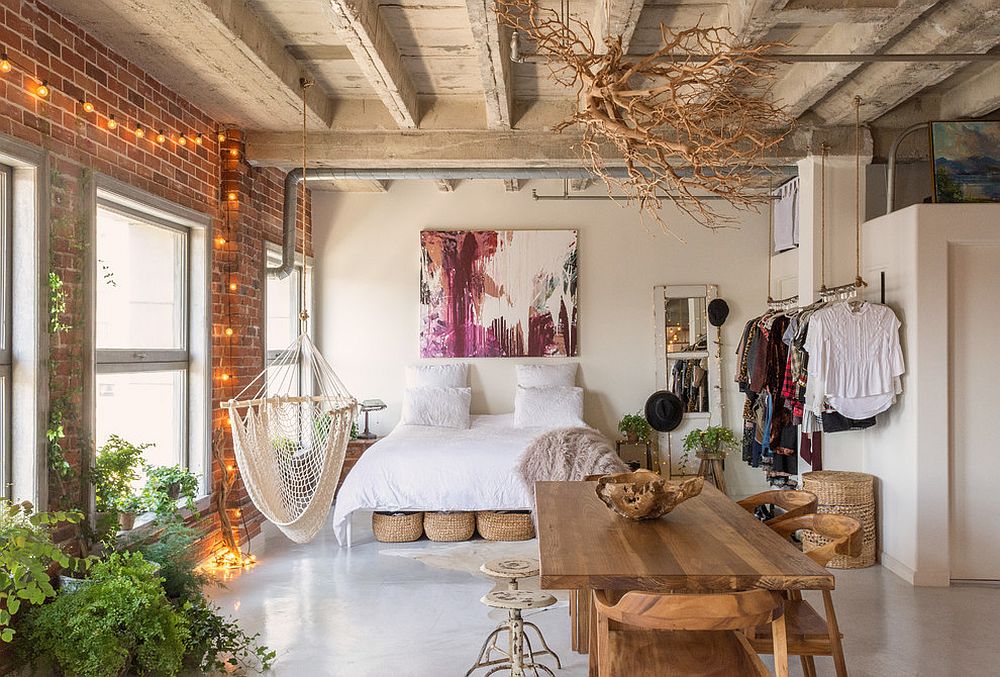 Eclectic chic bedroom with brick wall, exposed concrete ceiling and string lighting