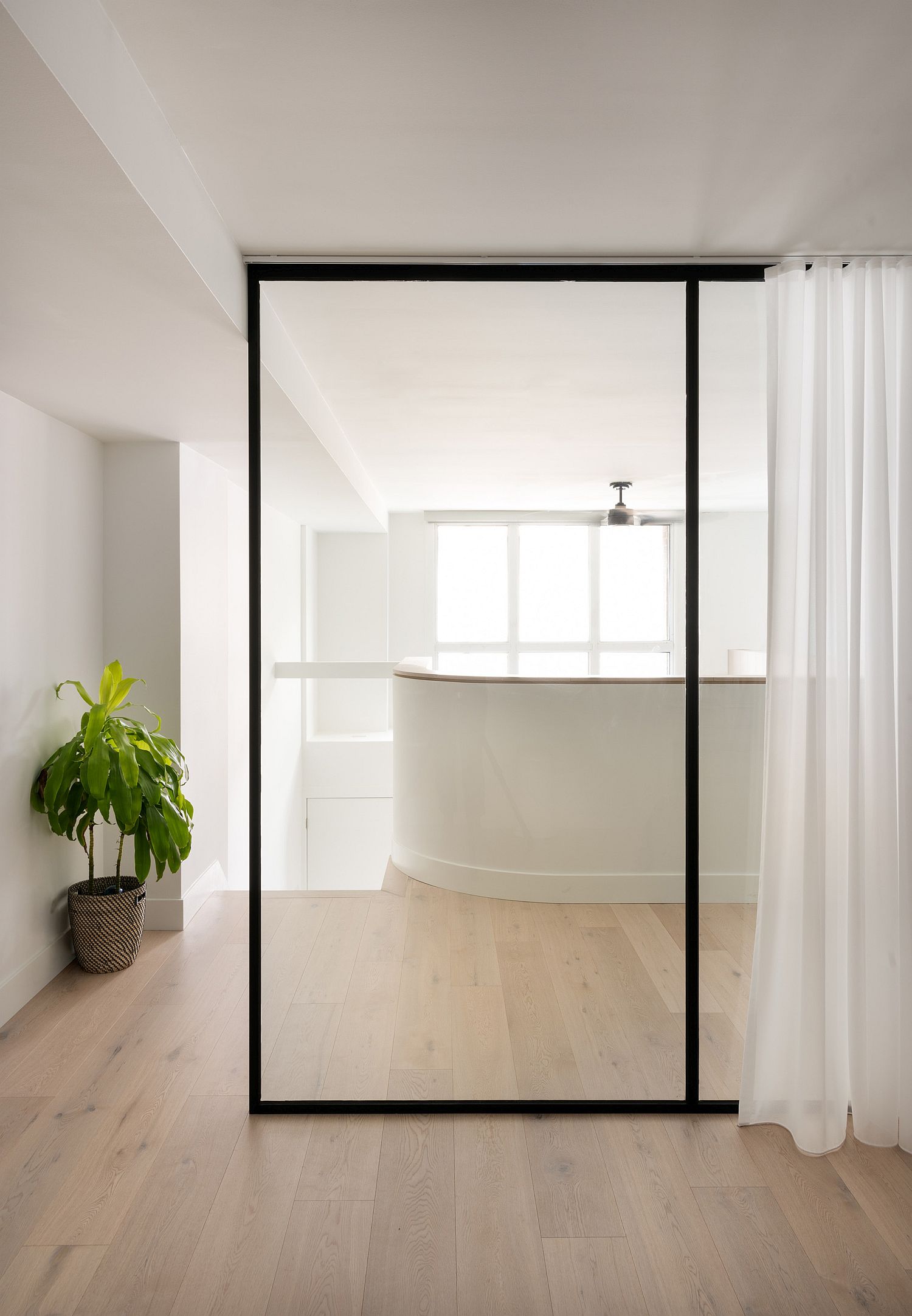 Glass-doors-with-minimal-black-frame-and-white-drapes-for-the-modern-bedroom