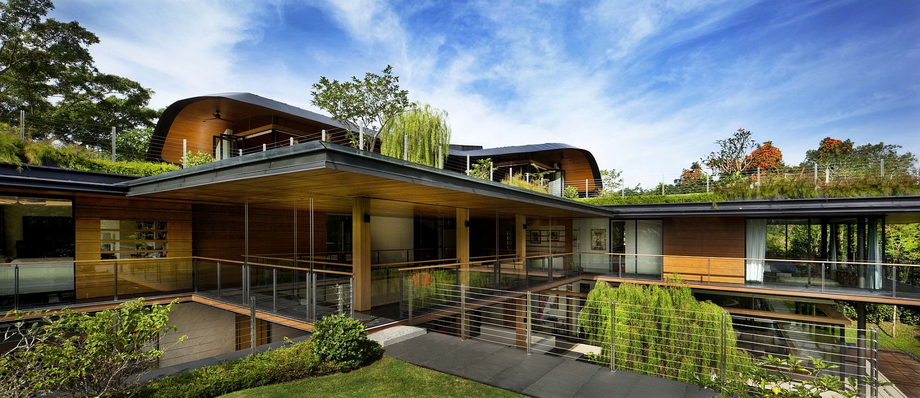 L-shaped home with walkways and greenery all around