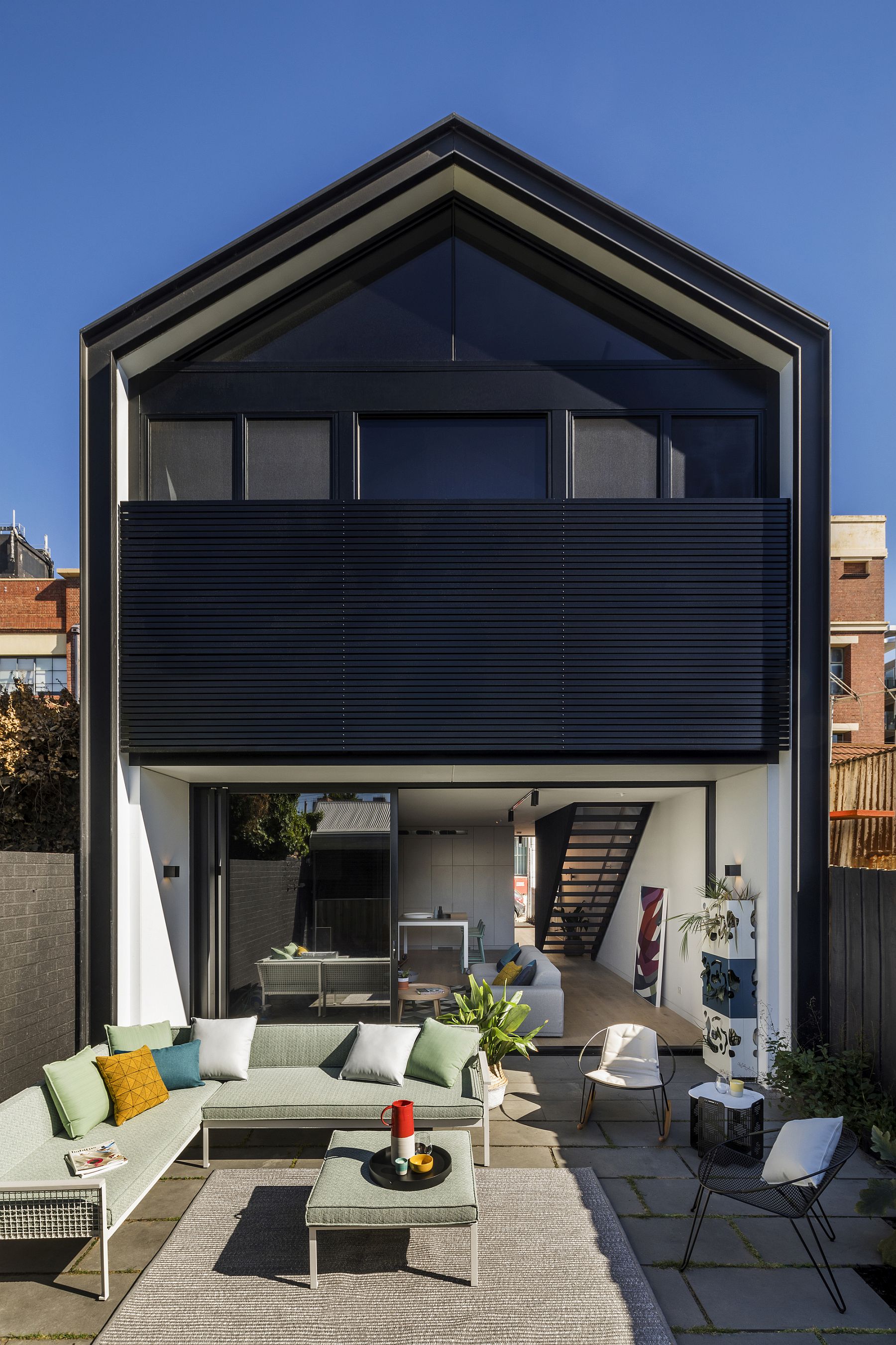 Rear facade of the house feels much more open as it invites the deck inside