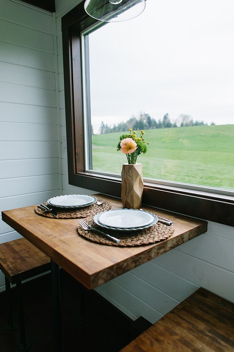 Small and beautiful dining area next to the window with wooden seats for two