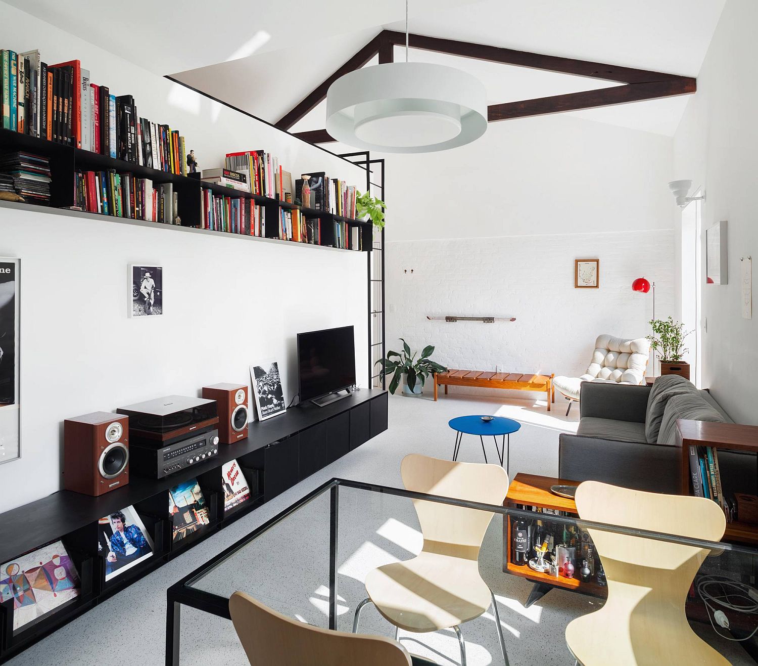 Small-space-savvy-apartment-has-a-living-room-with-bookshelf-that-is-placed-above-entertainment-unit