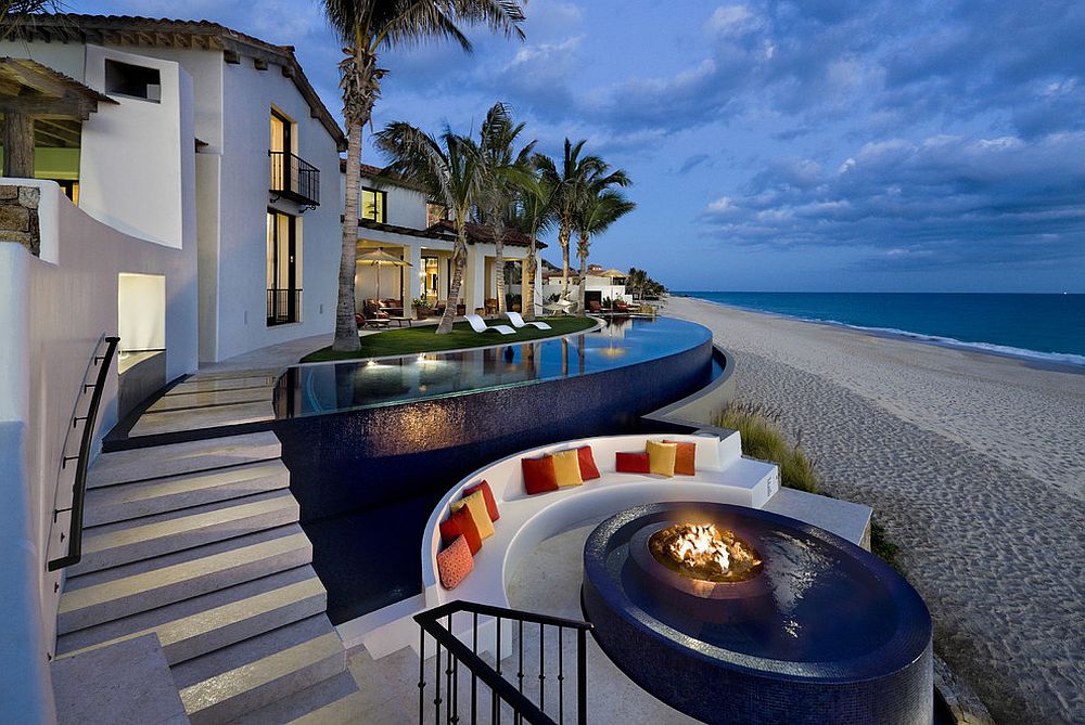 Tropical pool with fire pit at its heart next to the beach and sunken seating