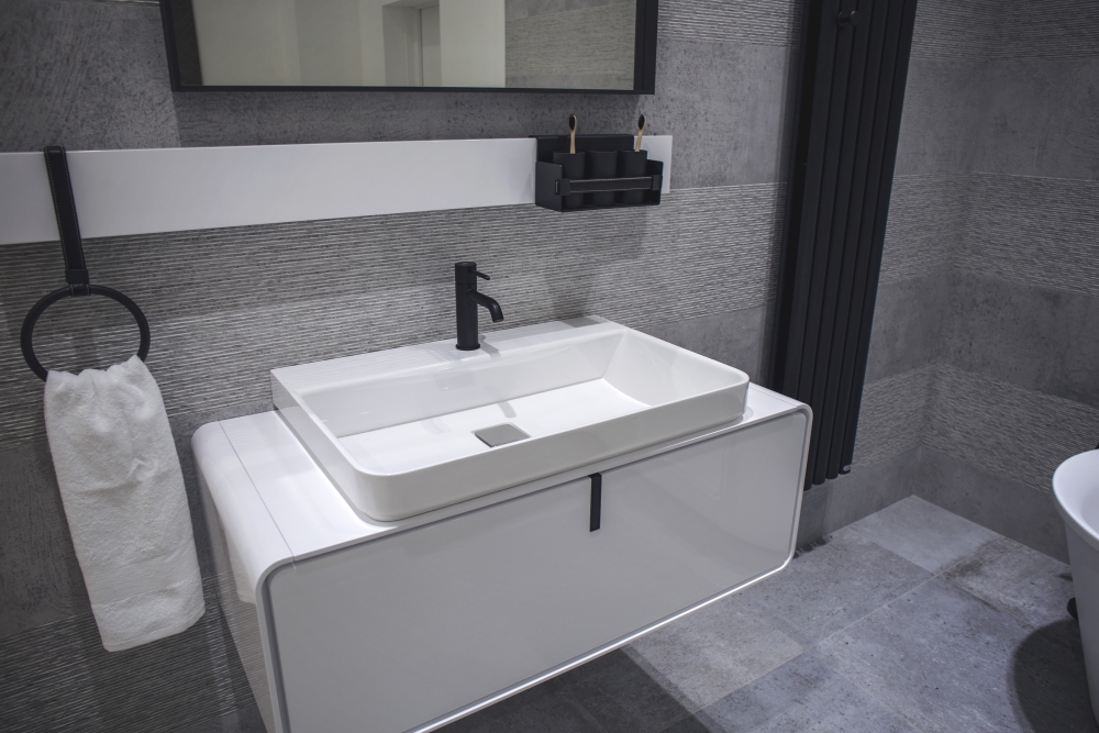 Bathroom with stone-like wall tiles and contrasting white vanity