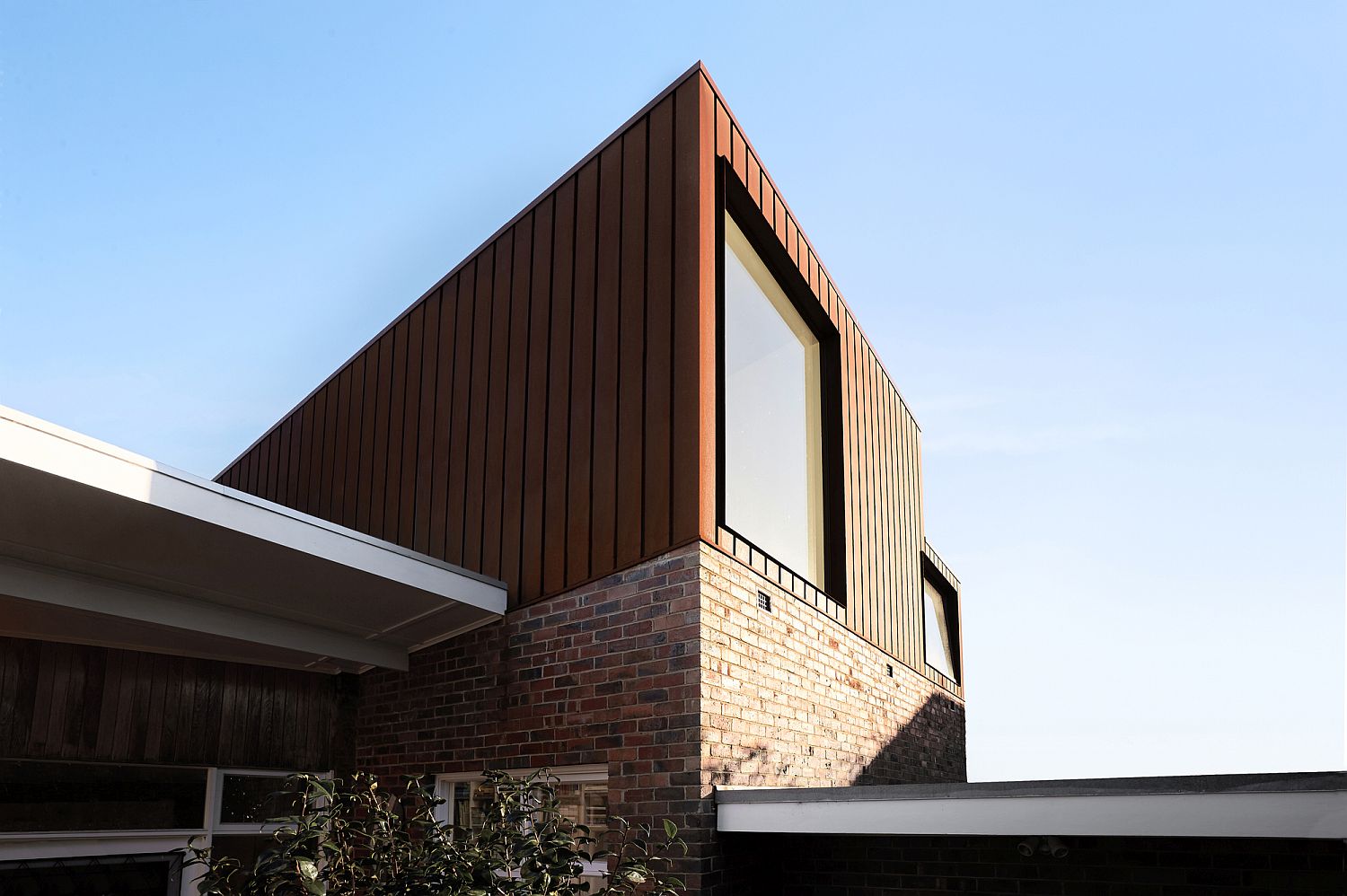 Brick coupled with corten panels creates a stylish and unique exterior