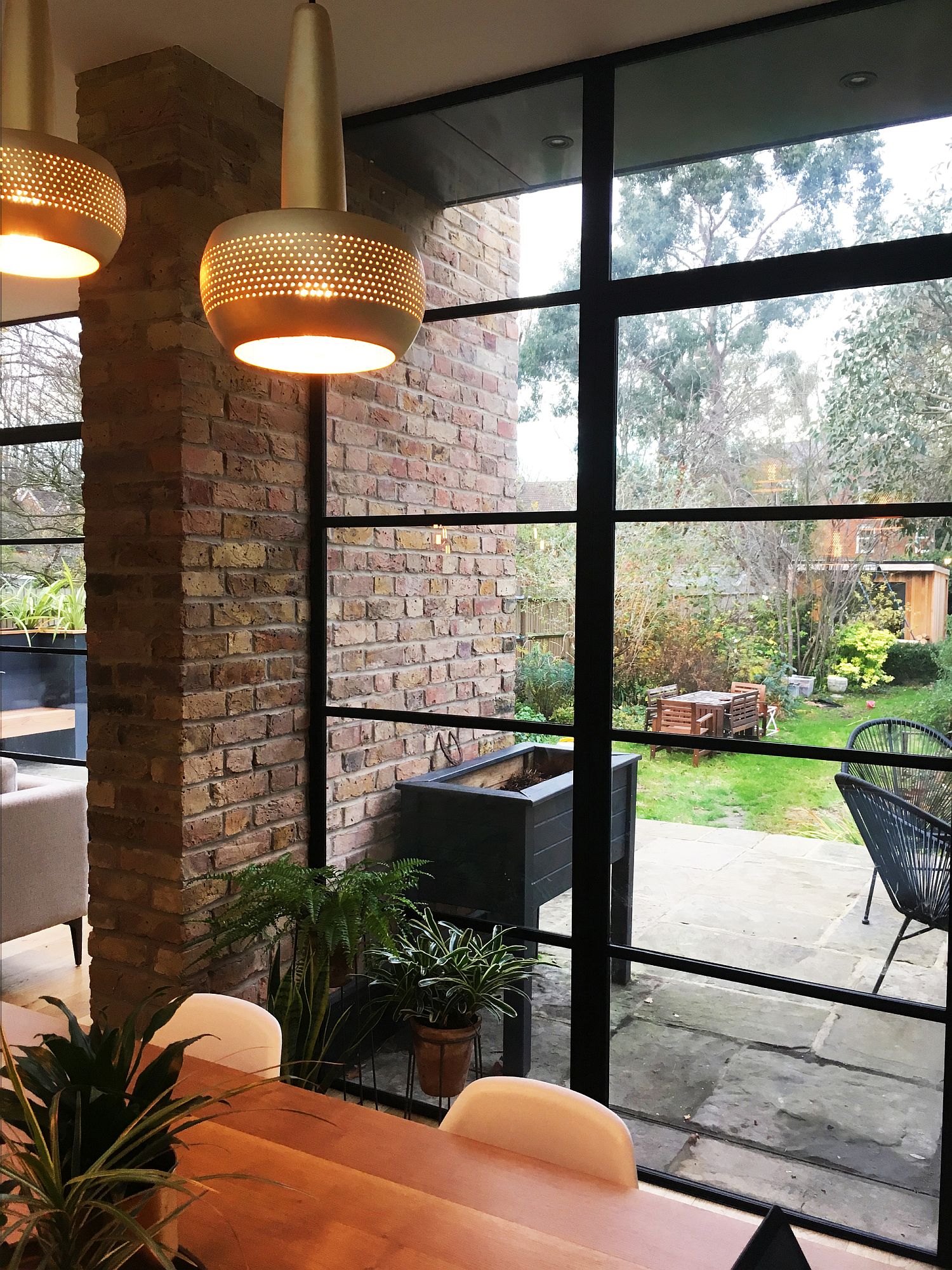 Brick walls coupled with framed glass windows inside the house