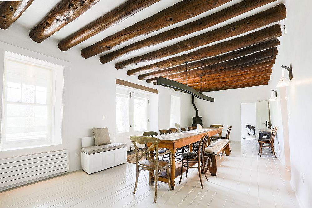 Ceiling beams create a stunning visual inside this white and wood dining room