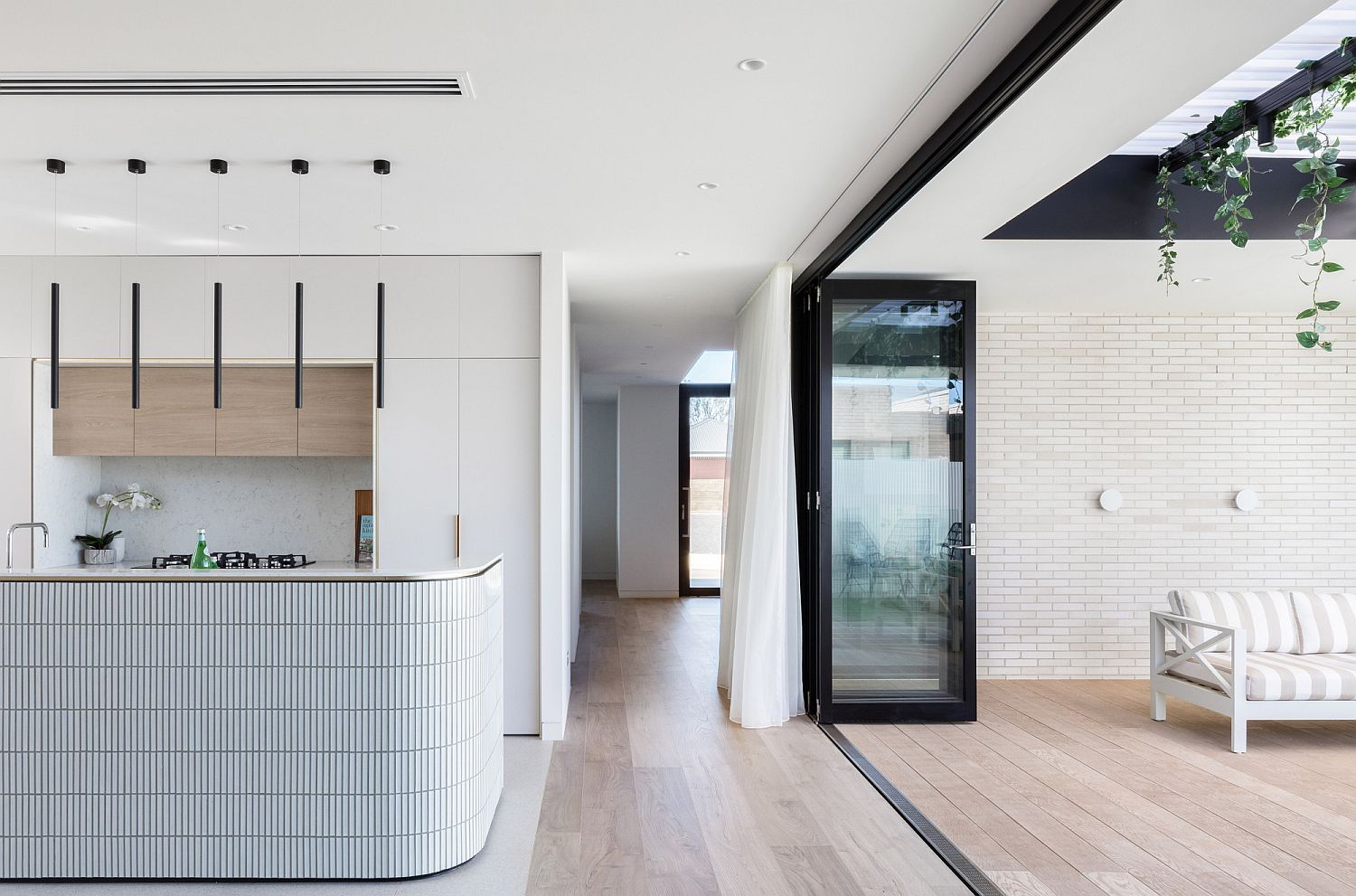 Curved kitchen island design complements that of the wall outside