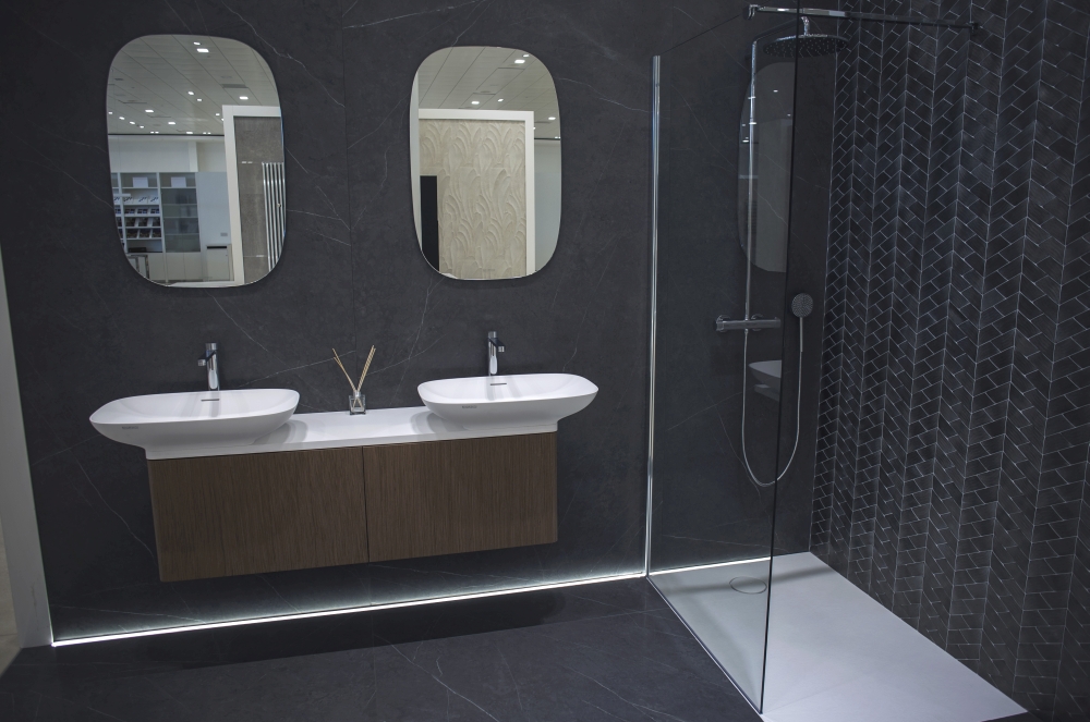 Dark themed bathroom design with double vanities