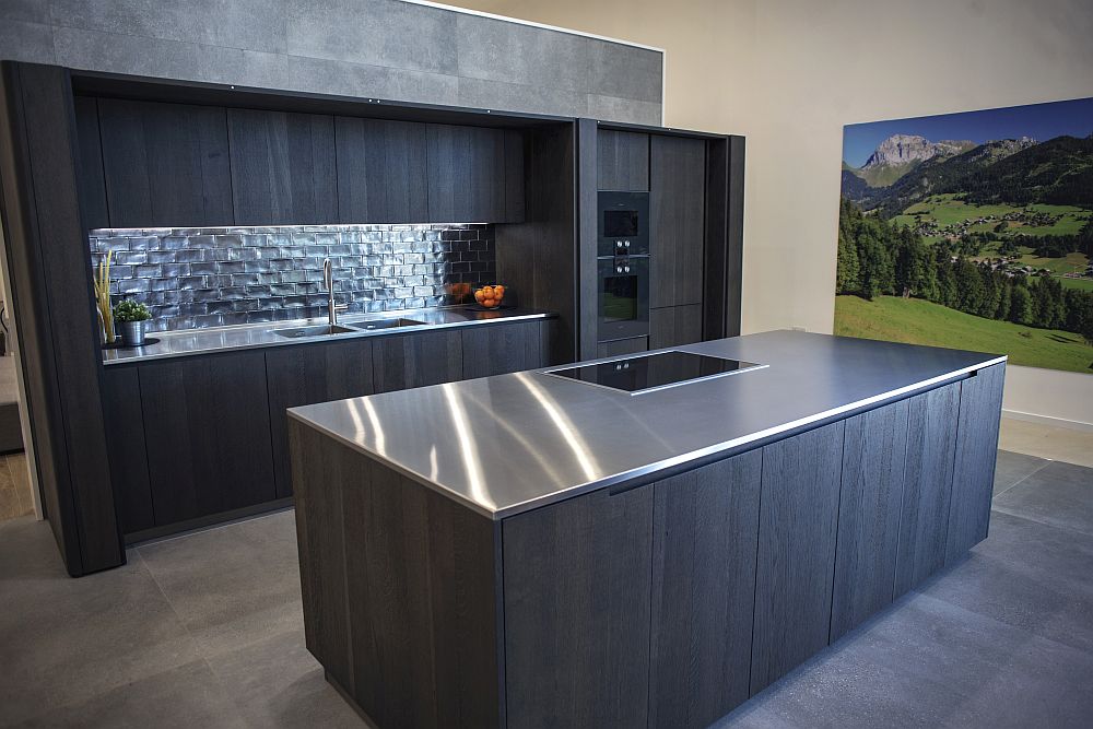 Dark themed large kitchen design with stainless-steel countertops