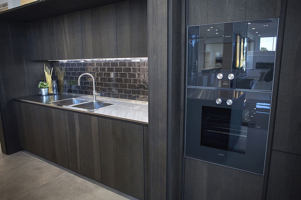 Dark wood kitchen with glossy subway tiles backsplash and under-cabinet lighting