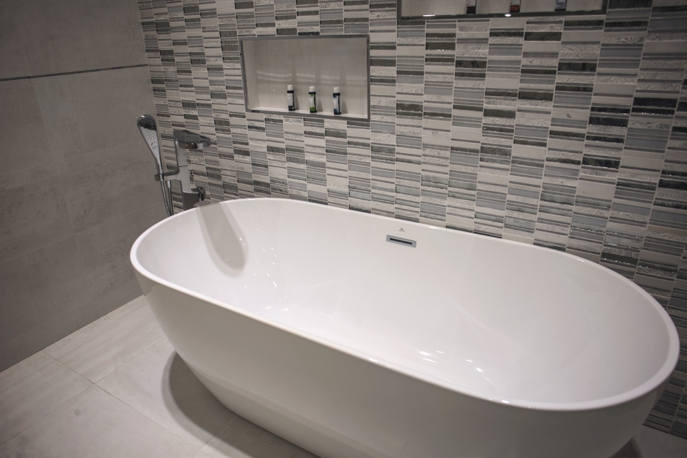 Free-standing-bathtub-with-glossy-tiles-backdrop-Porcelanosa