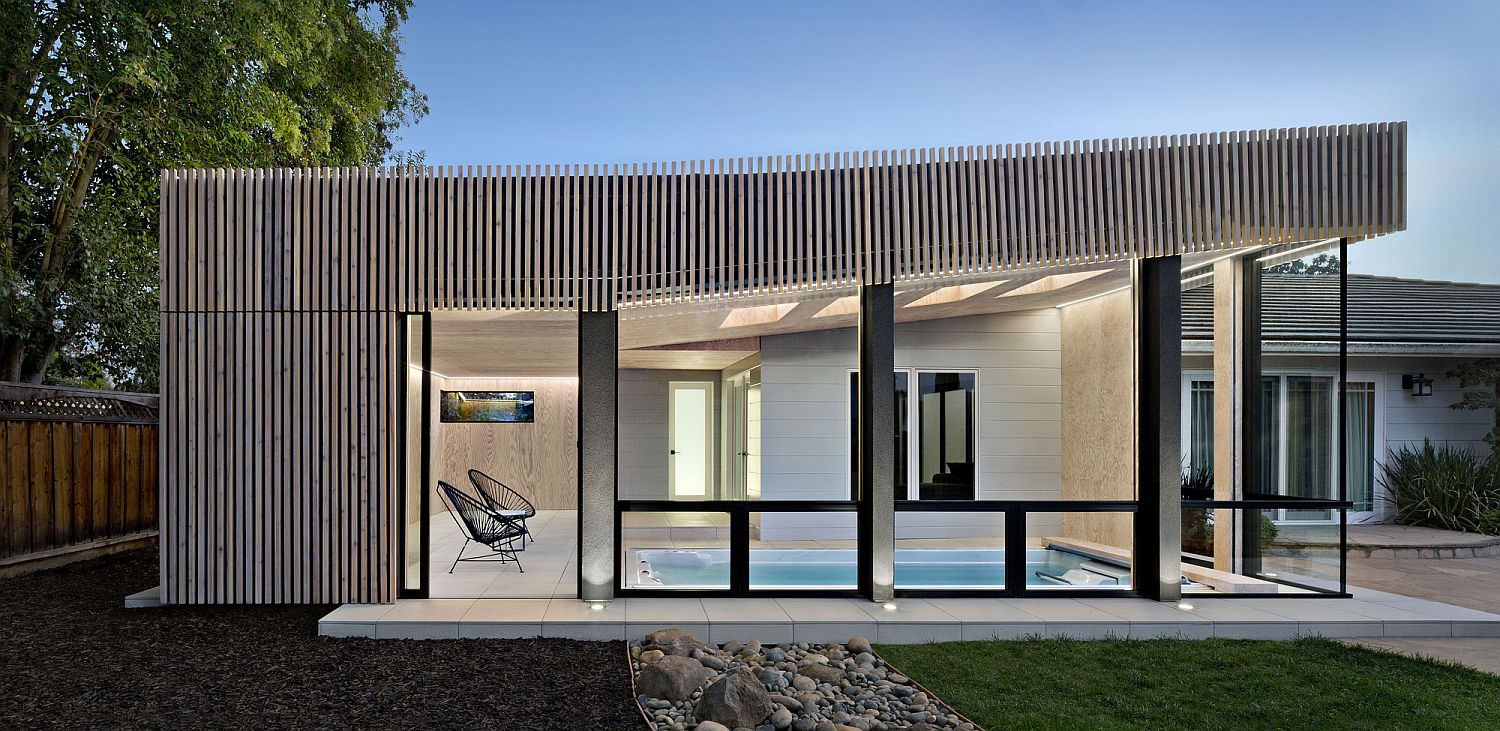 Glass walls bring ample natural light into the pool house during daytime