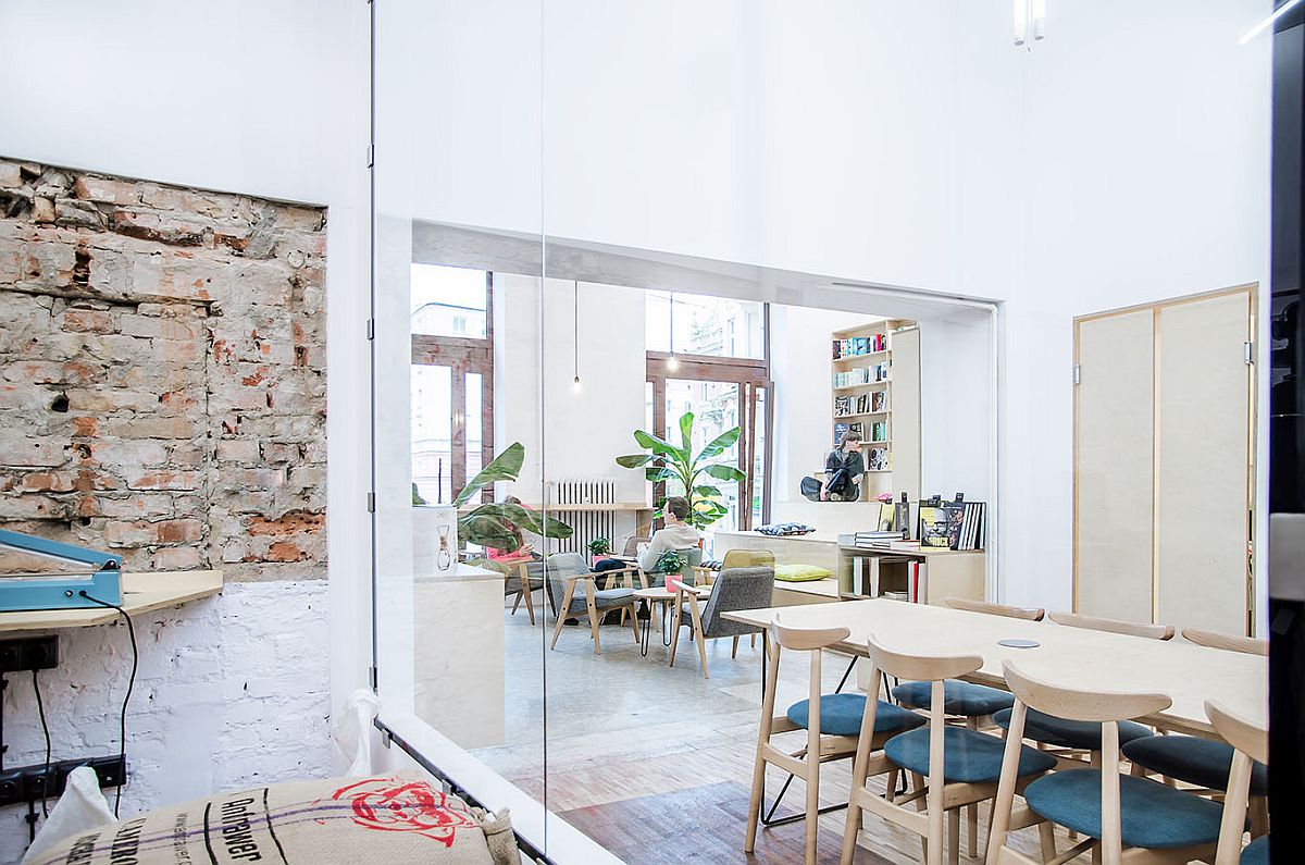 Glass walls combined with brick wall section and contrasting finsihes inside the coffee shop