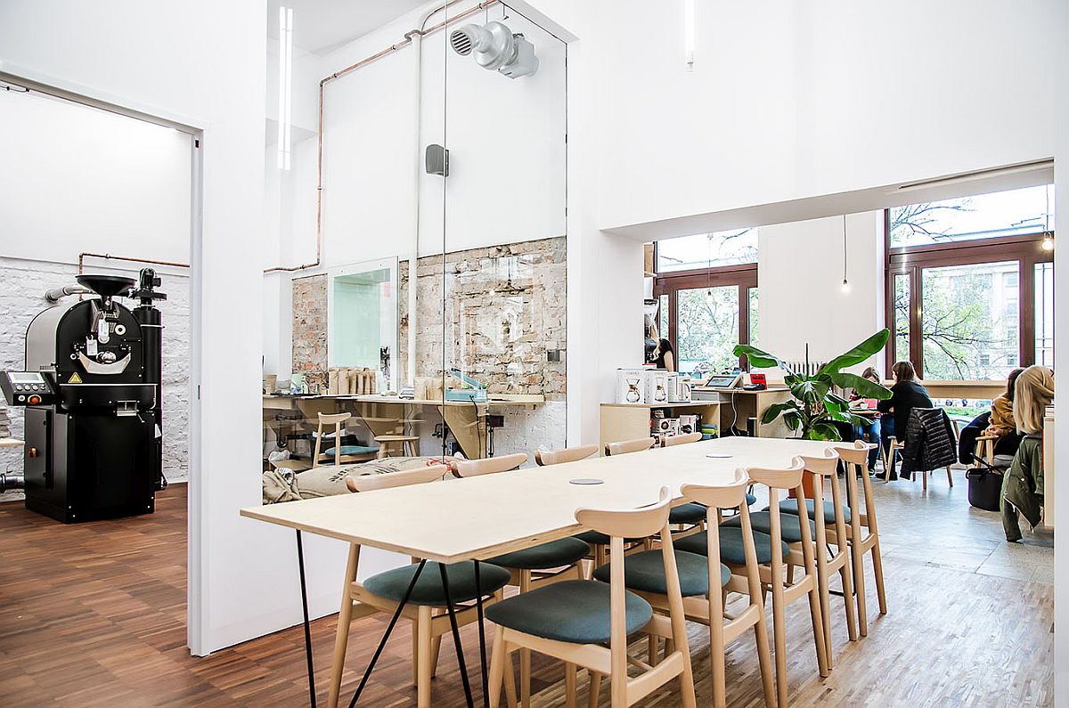 Large-wooden-table-and-plpush-chairs-create-a-smart-dining-and-workshop-area-inside-the-coffee-shop
