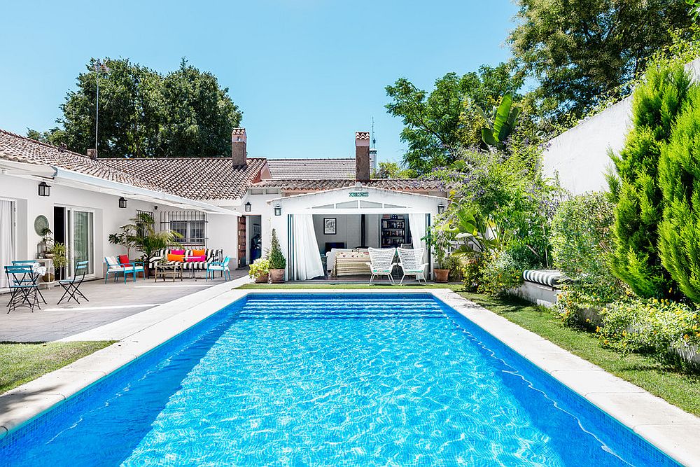 Mediterranean pool house in white with terra cotta tiles brings home the holidays