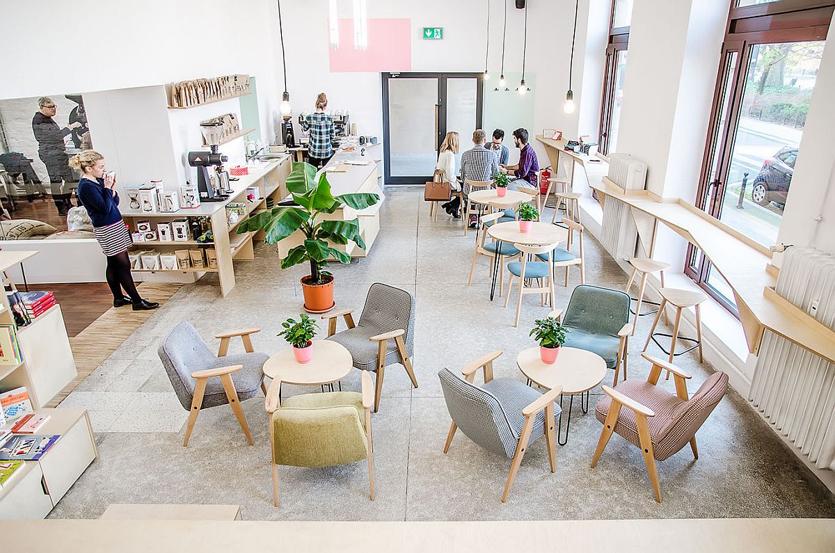 Minimal lighting and refurbished chairs, tables give the space an industrial modern vibe