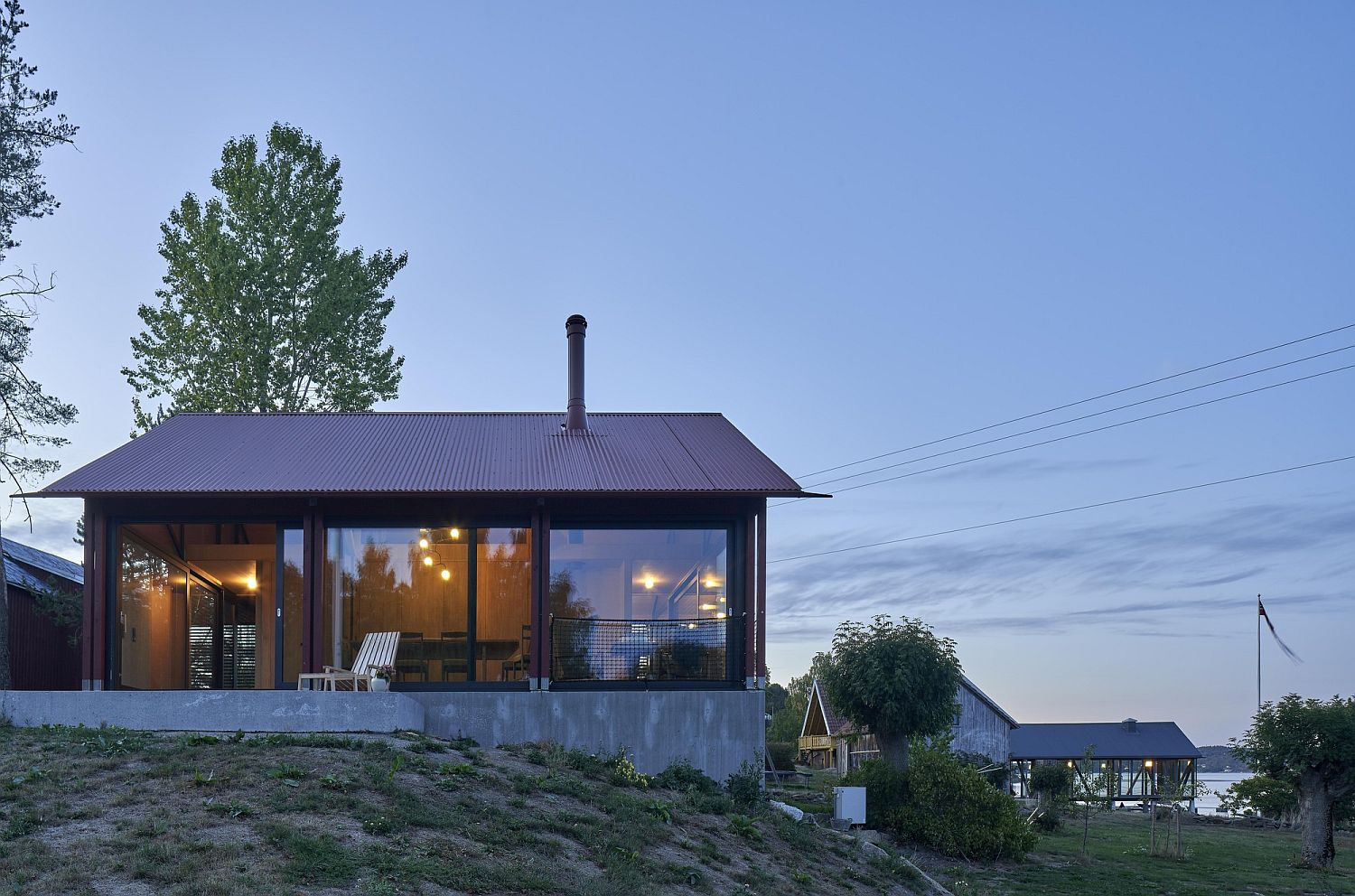 Sweeping floor-to-ceiling glass doors connect the cabin with Sandefjord landscape