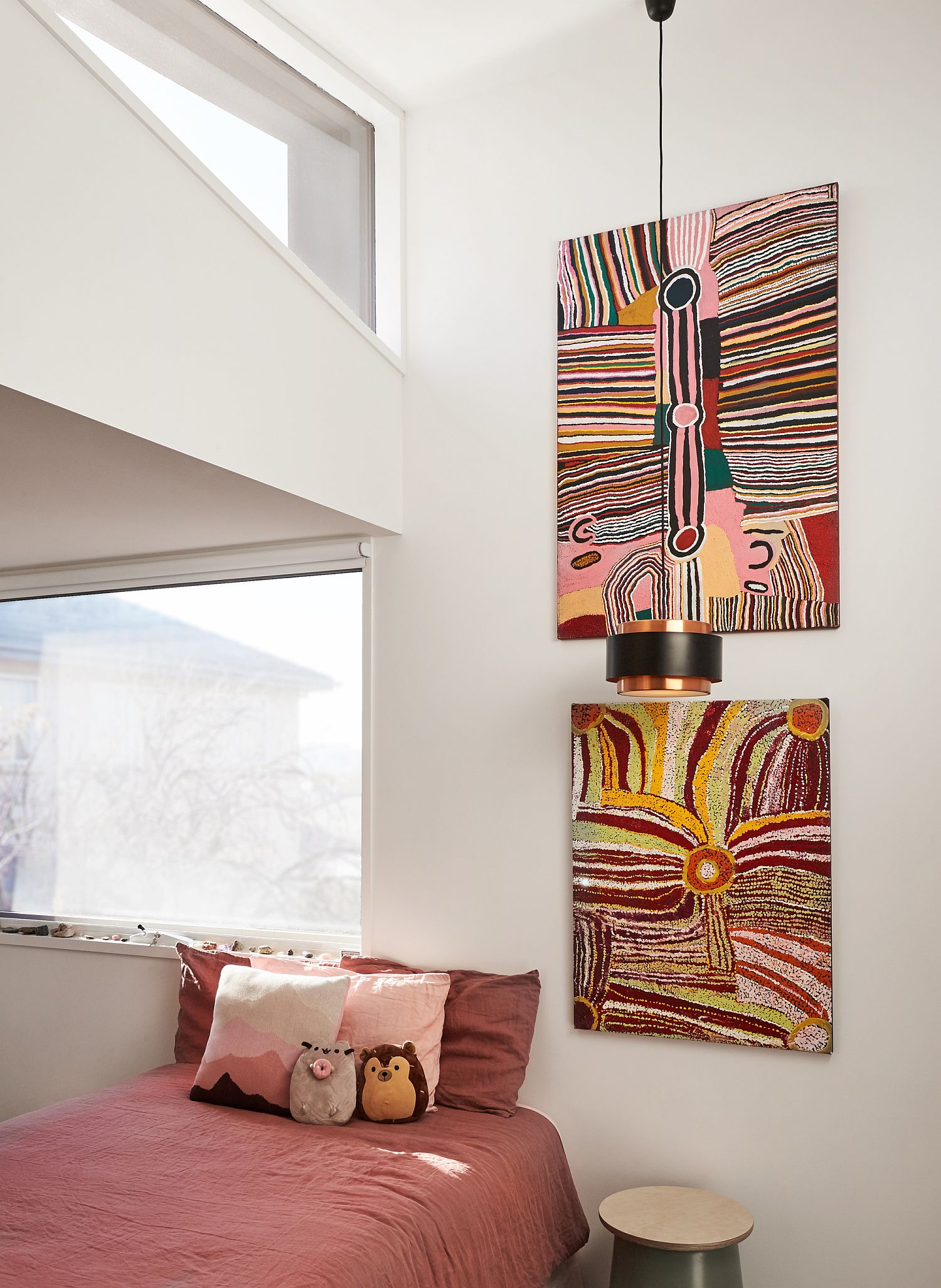 White kids' room with cheerful bedding and art work