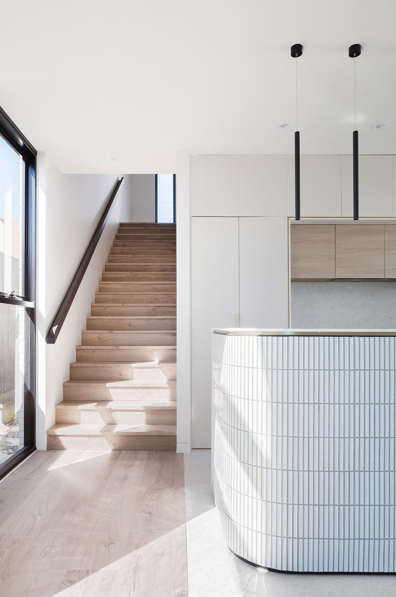 Wooden stairway next to the curved kitchen island