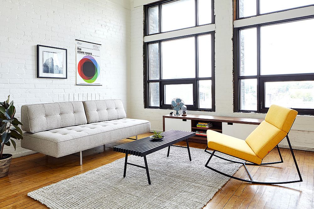 Yellow recliner coupled with light gray sofa and white brick wall backdrop in the living space