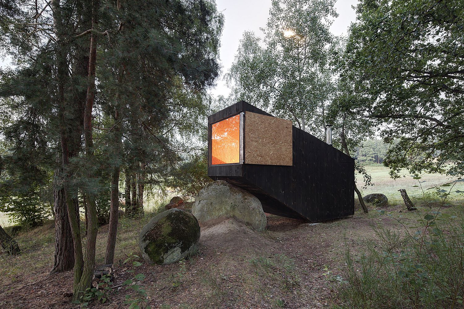 Cantilevered end of the cabin rests on a large natural boulder