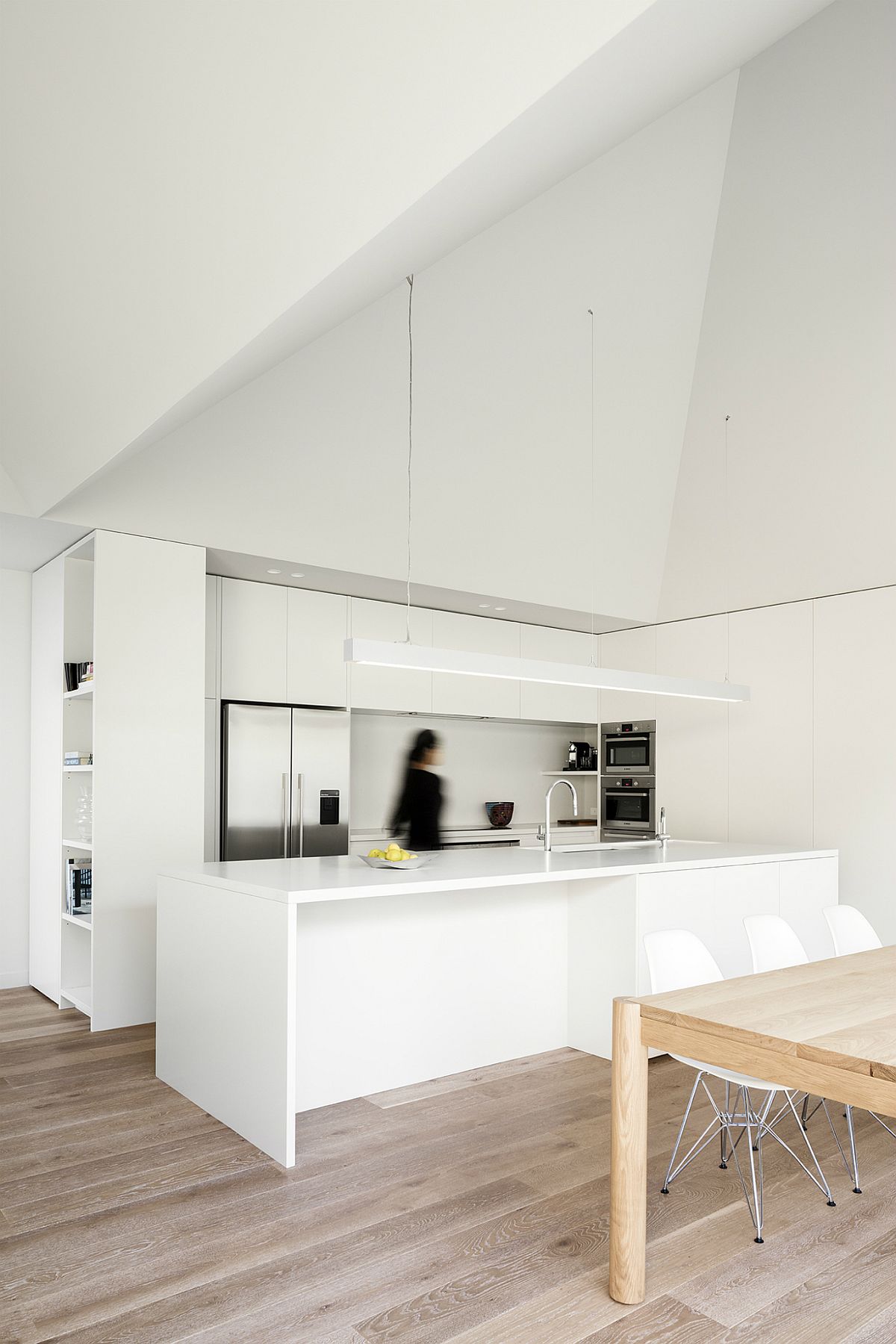 Dining-table-next-to-it-brings-the-woodsy-element-to-this-polished-corner-kitchen-in-white