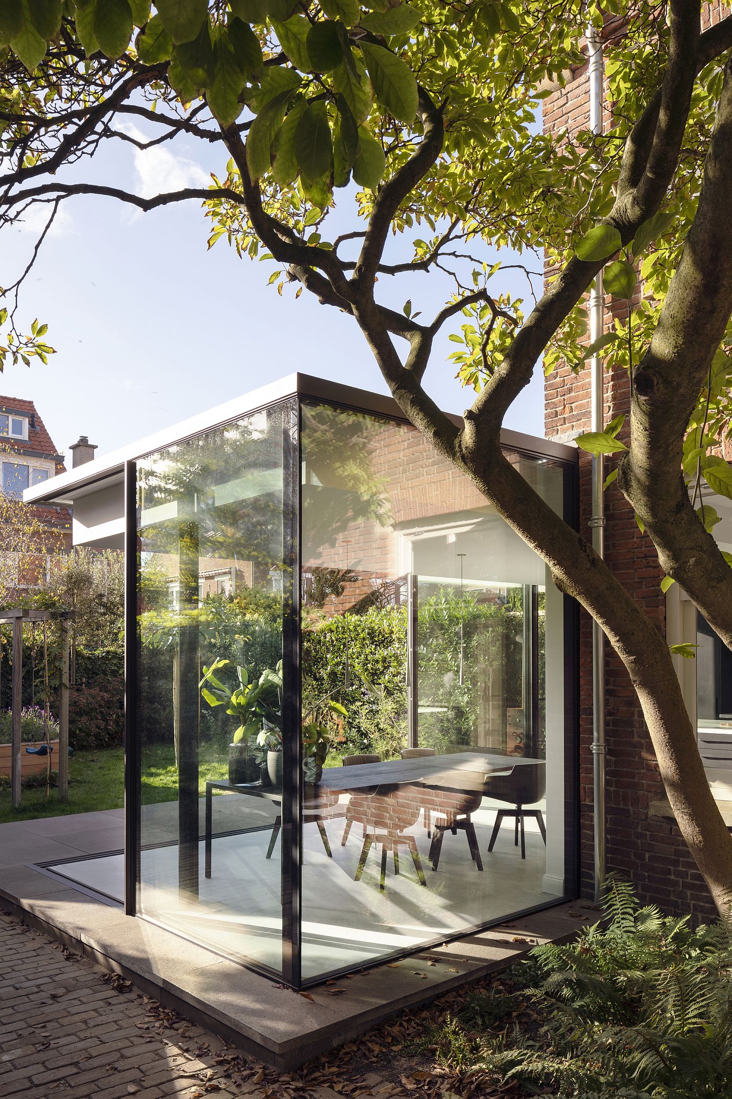 Glass walled extension of the traditional brick house in Netherlands