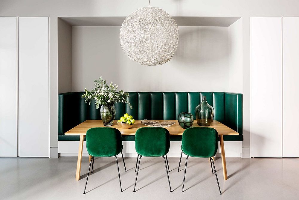 Gorgeous use of dark green chairs and banquette seating in the white dining room with Moooi Random Light