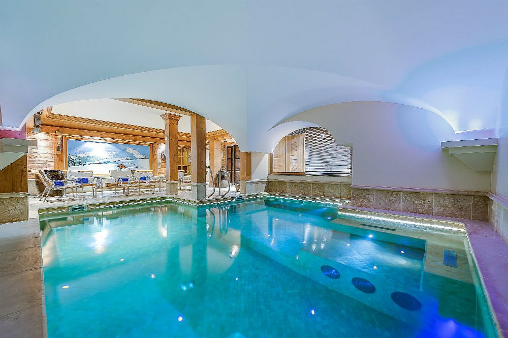 Indoor heated pool with water jets and a private spa next to it