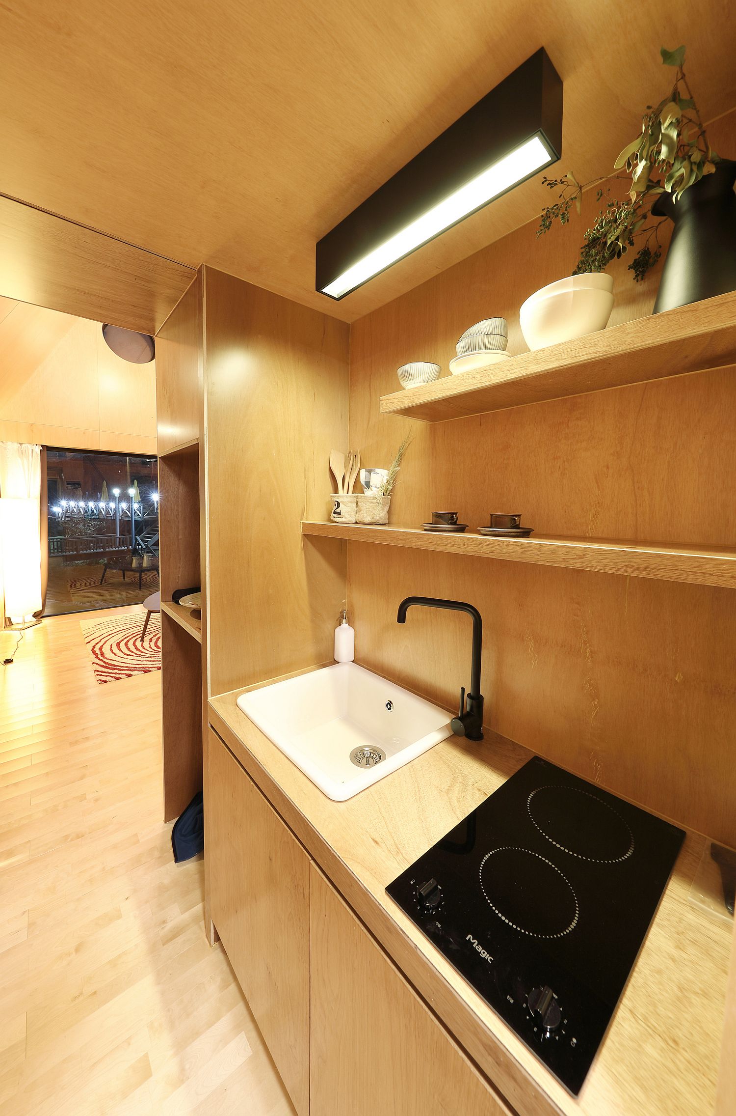 Kitchen of the tiny house with wooden shelves and smart cabinets