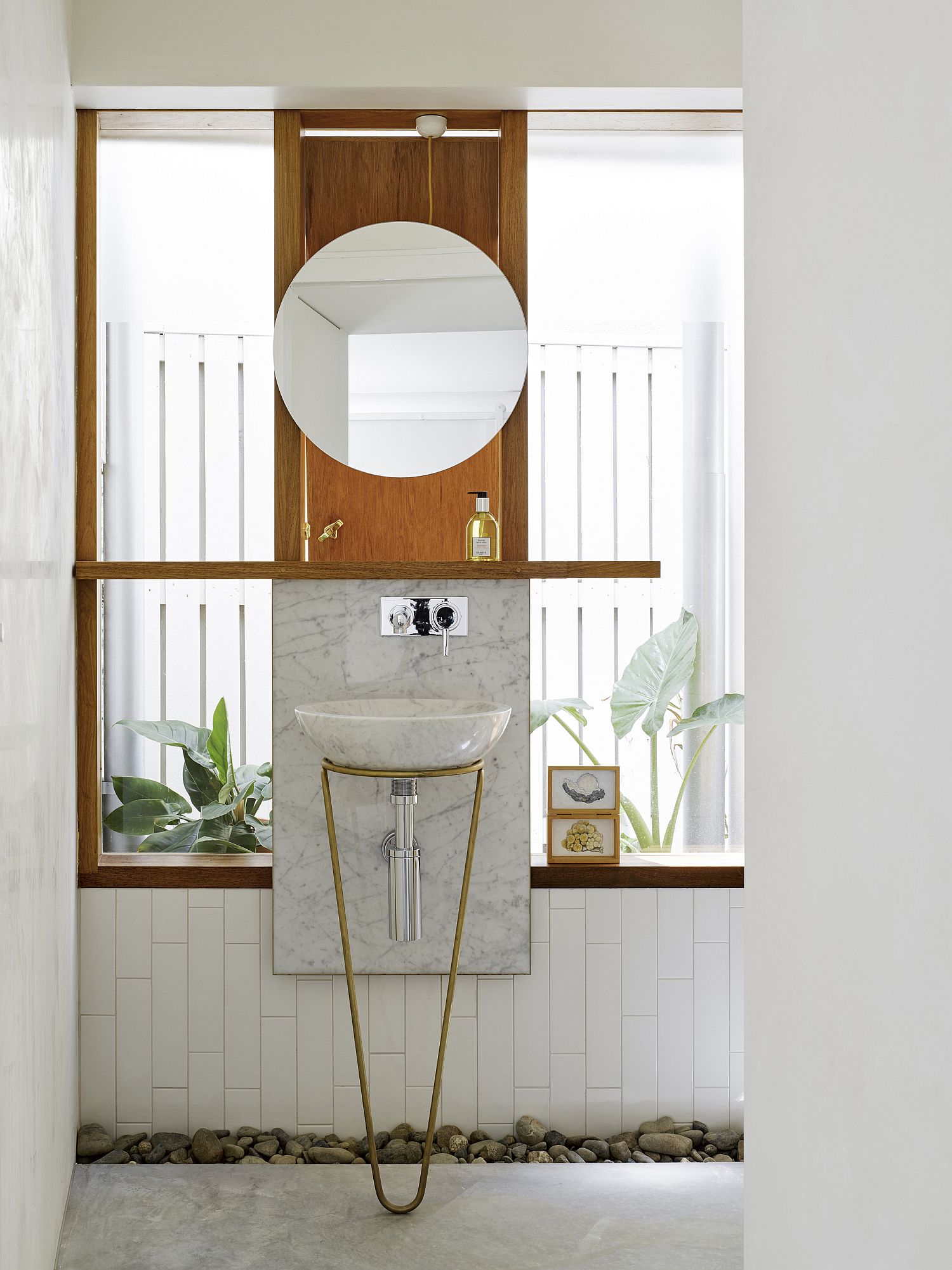 Marble and riverstone coupled with warm metallics and wood in the posh bathroom