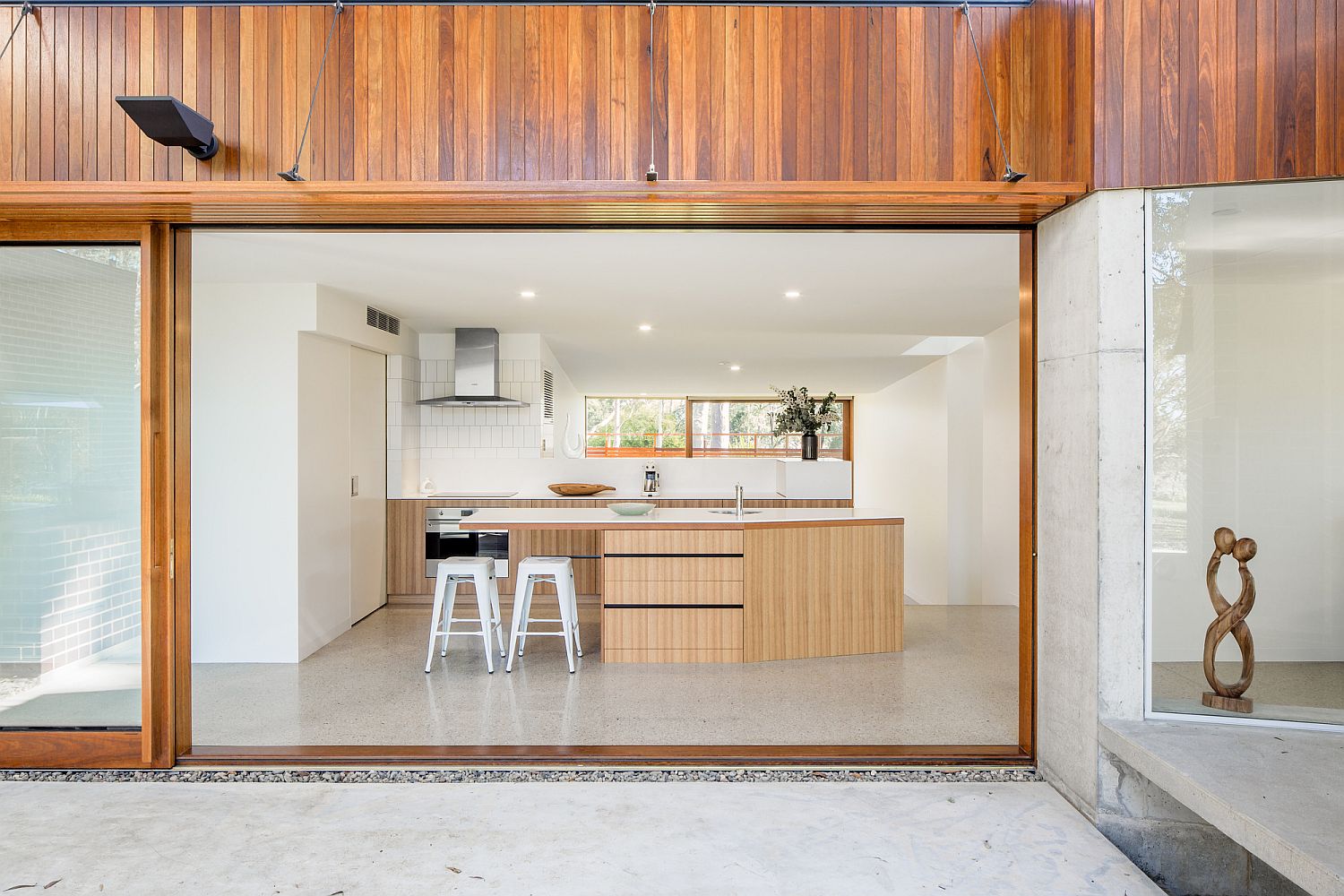 Sliding-glass-walls-with-wooden-frame-for-the-modern-kitchen-in-white