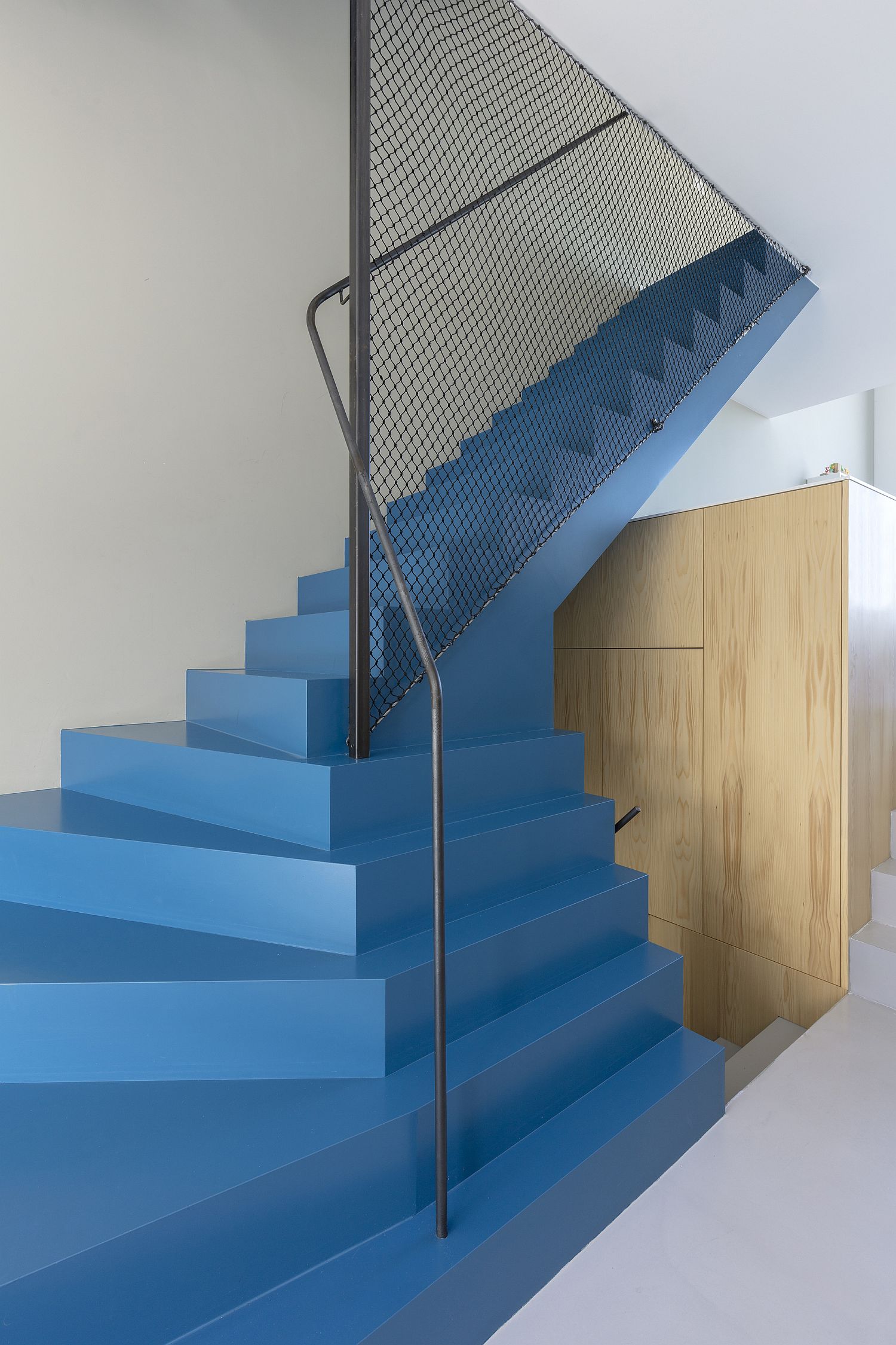 Striking blue staircase with mesh railing