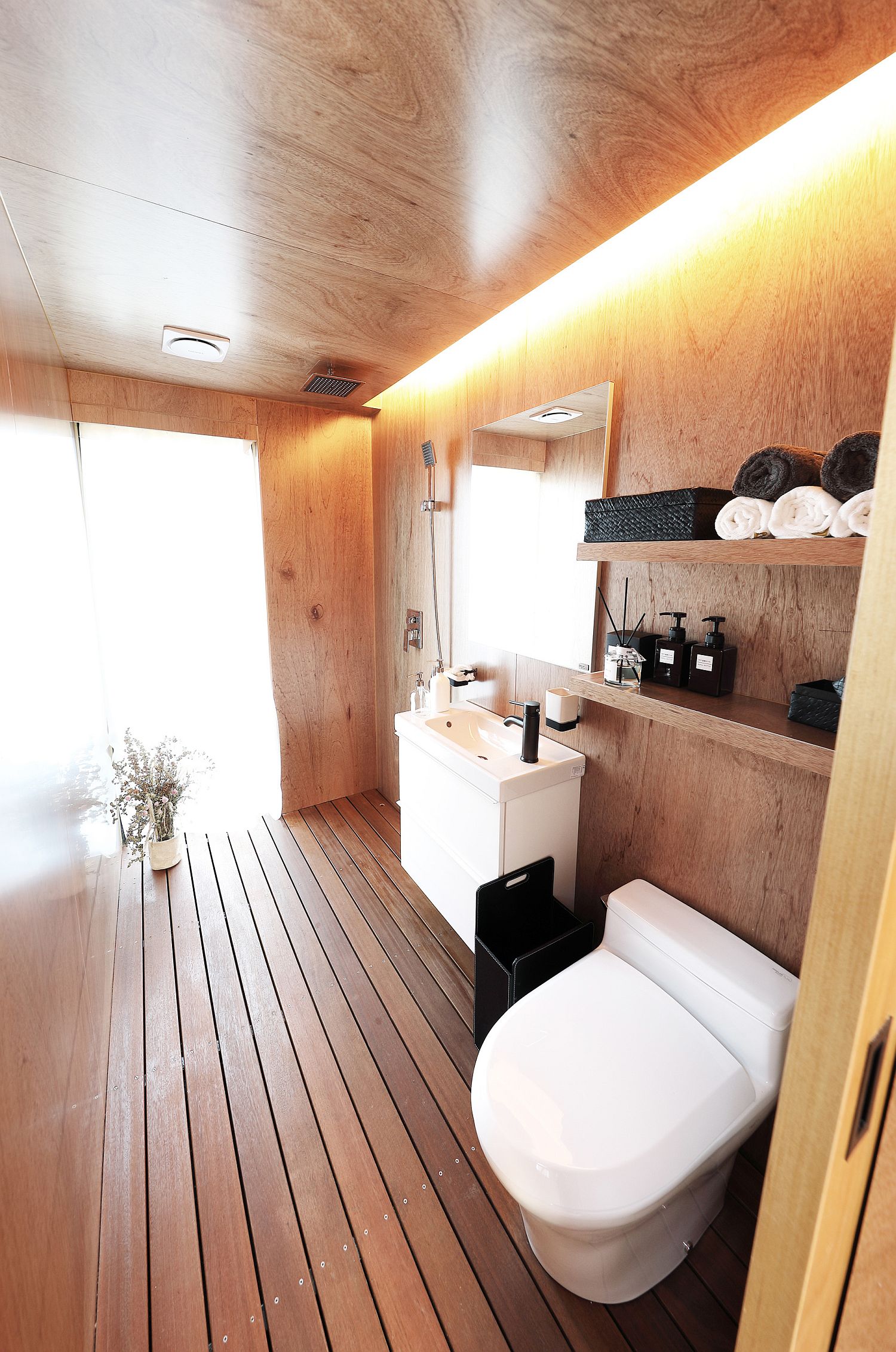 Wood bathroom with a pinch of white brought in by toilet fixtures