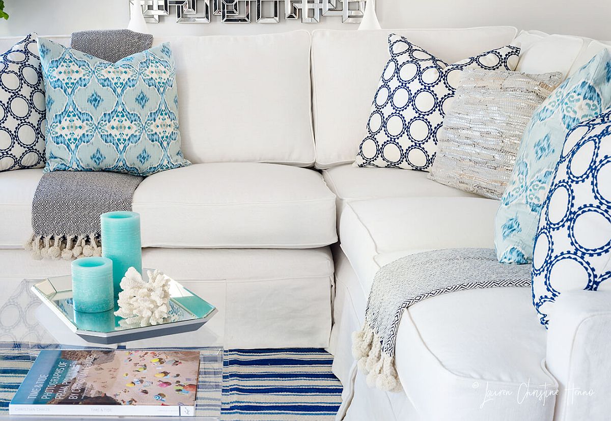 Accent pillows and decor bring blue to the white living room