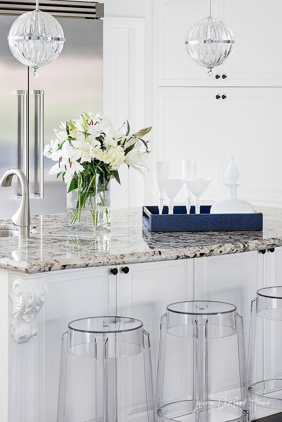 Acrylic bar stools add modernity to the beach style kitchen