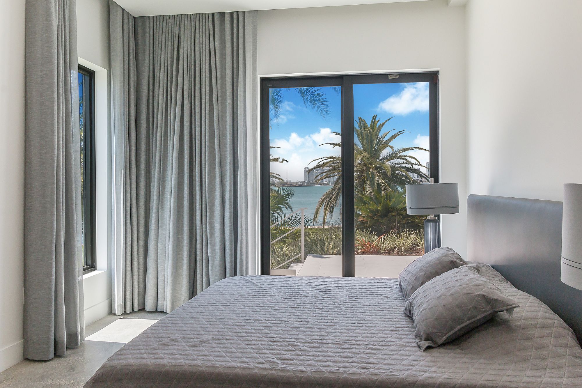 Beach style bedroom in white and gray with a view to match