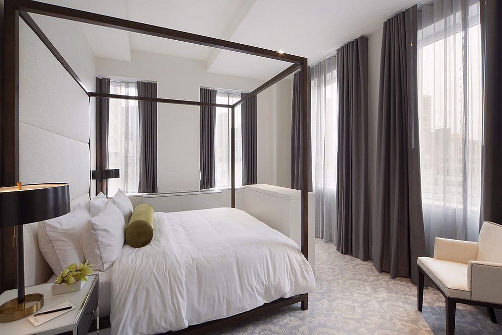 Bedroom in white with dark gray drapes