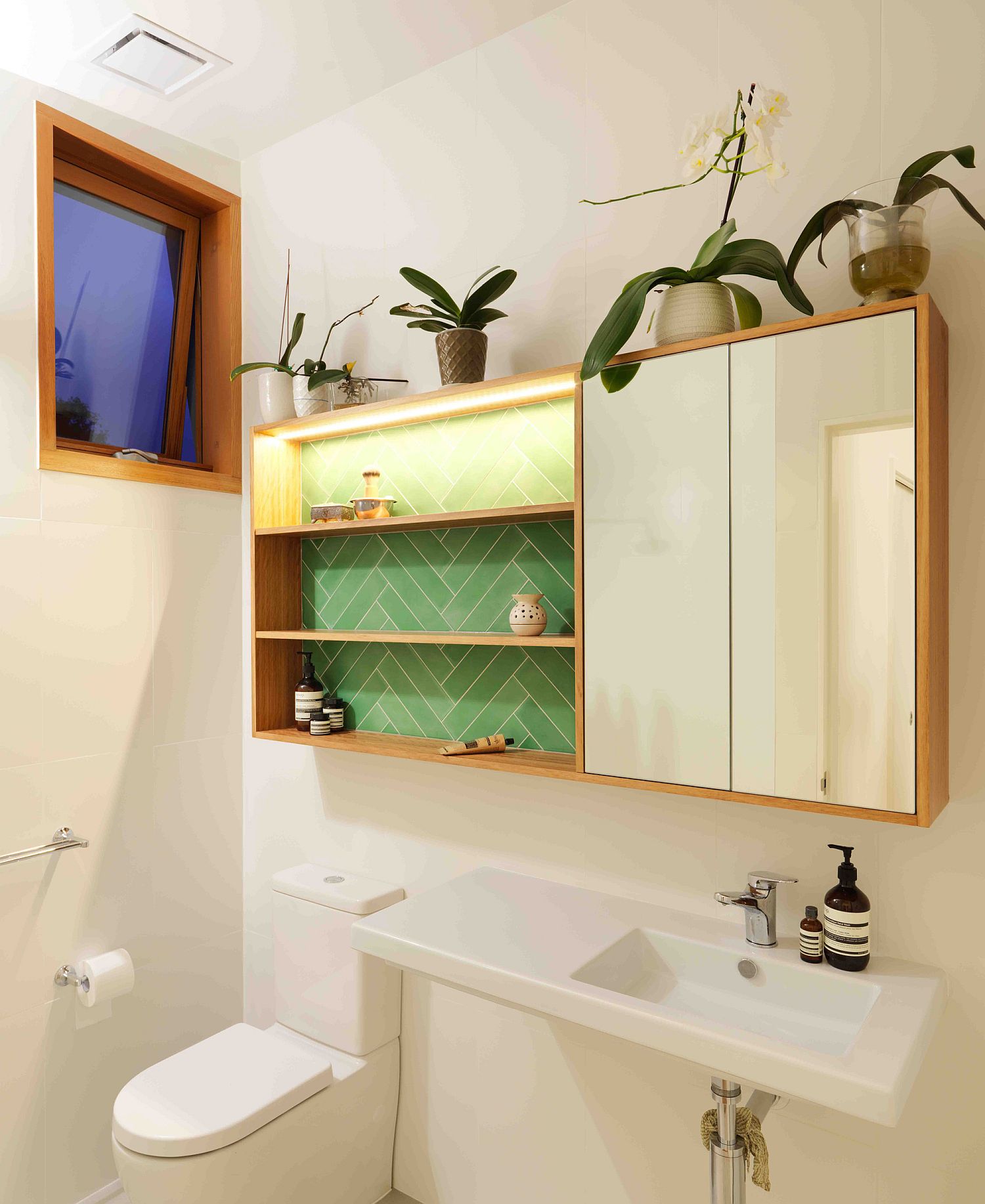 Bright and light-filled bathroom in white with wooden medicine cabinet