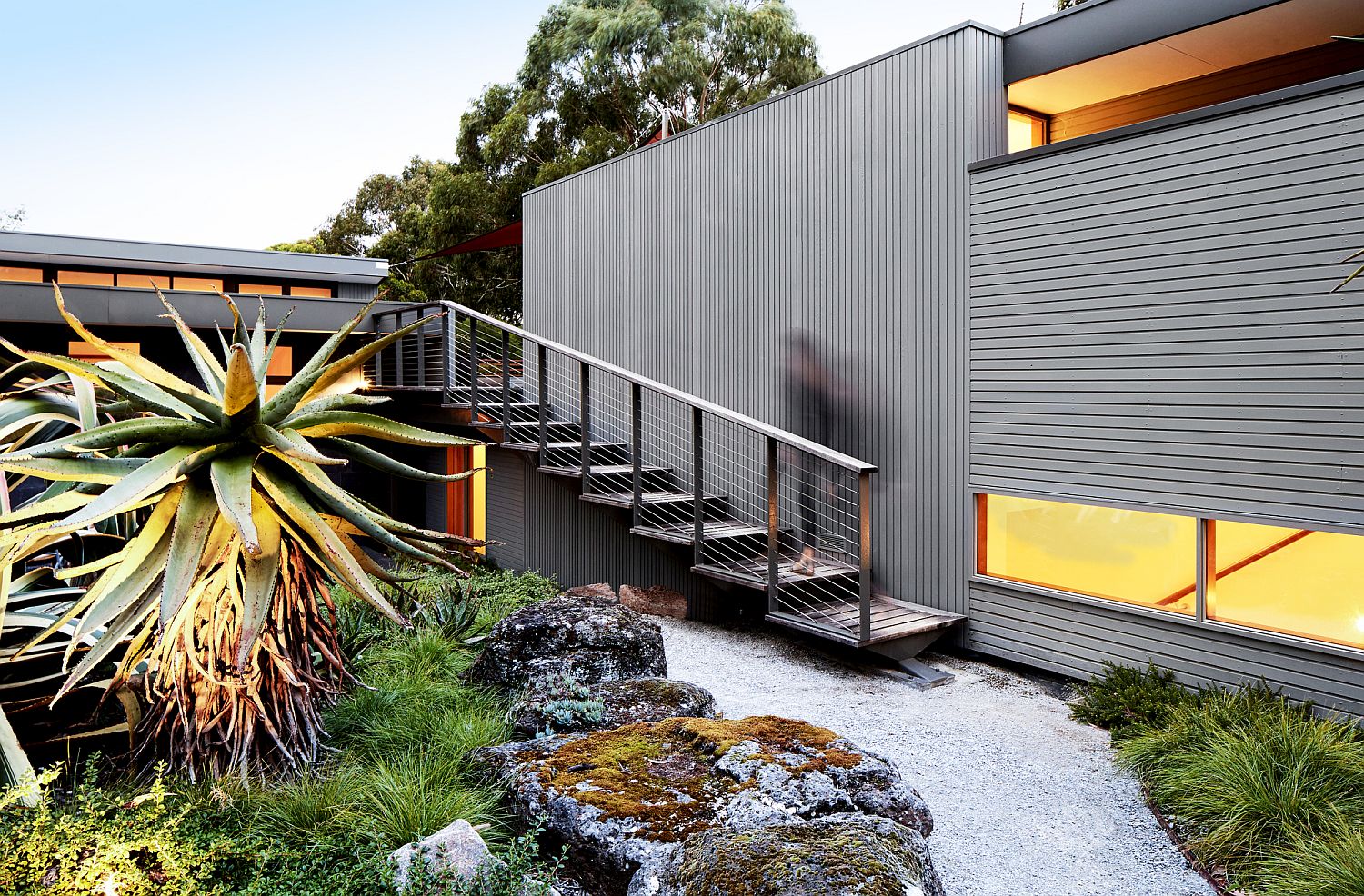 Clear staircase leading to the upper level combined with fabulously curated landscape