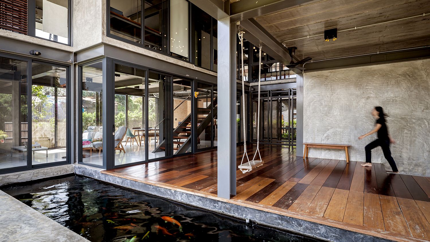 Glass walls, curated natural landscape and koi pond bring serenity to this spacious Bangkok home