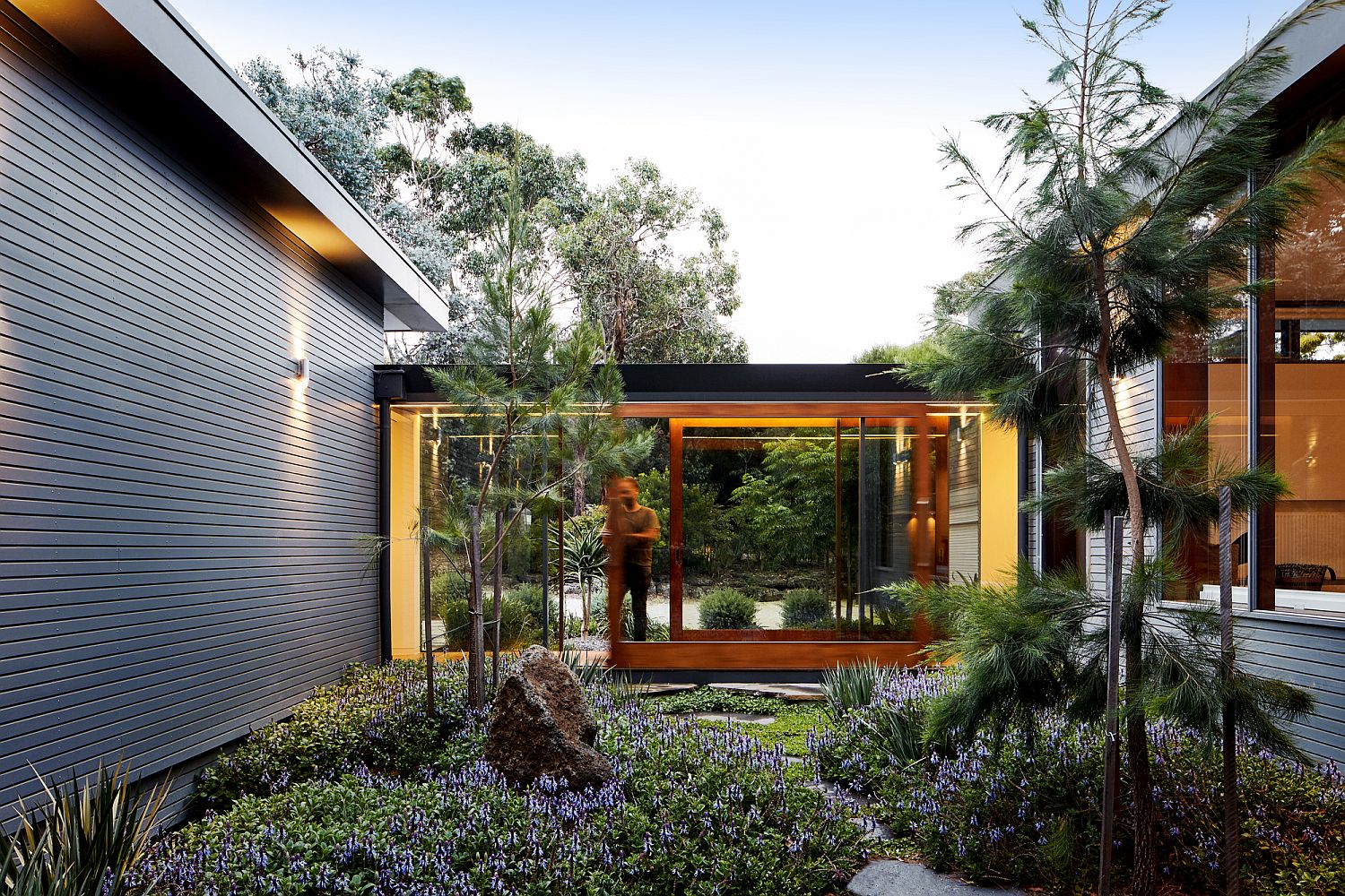 Glazed and covered walkway connects the two wings of the house